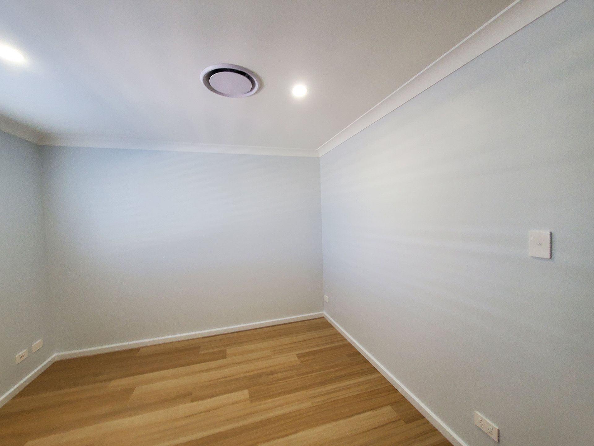 An Empty Room with Hardwood Floors and White Walls — JWP Painting & Property Services in Ettalong Beach, NSW
