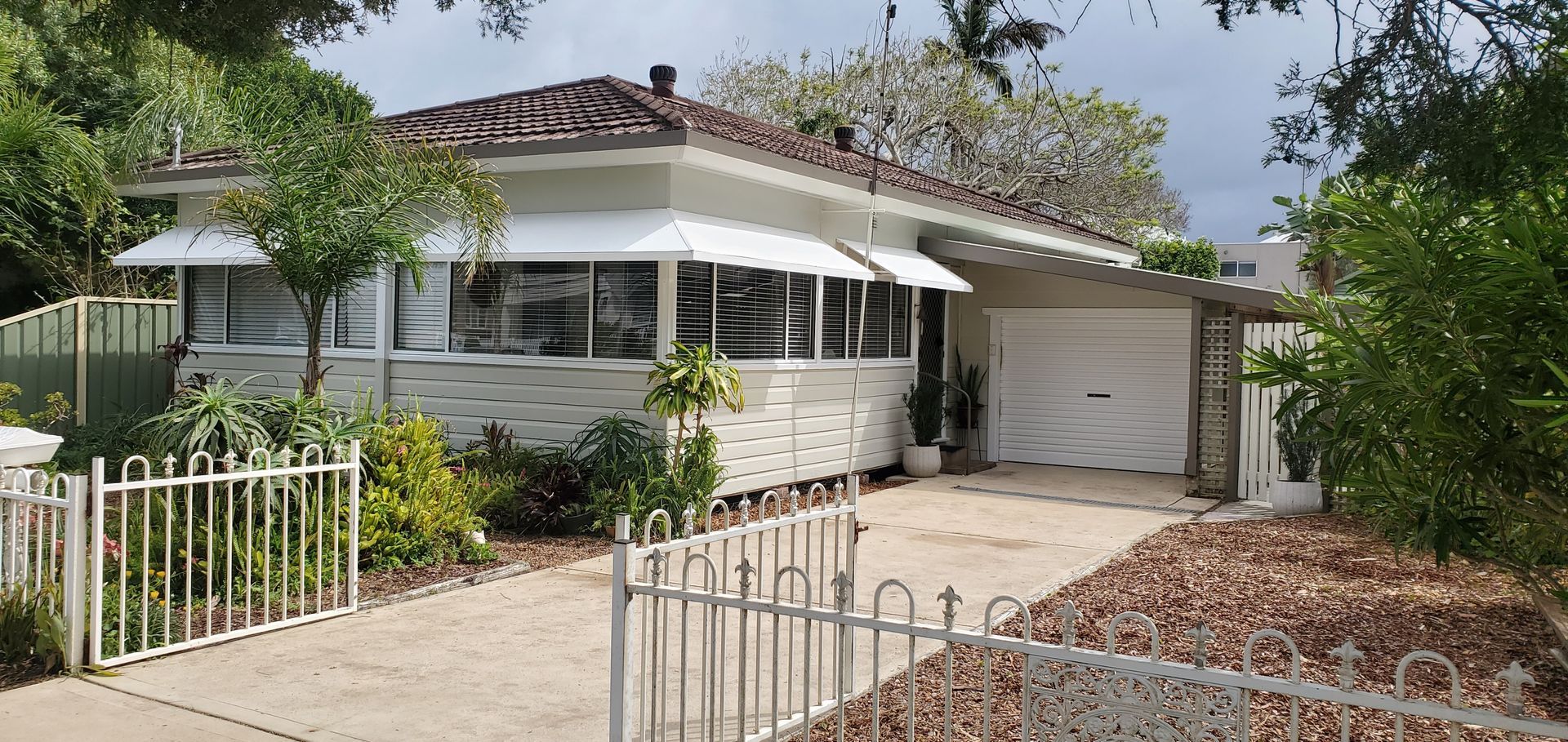 A white house with a white fence in front of it — JWP Painting & Property Services in Ettalong Beach, NSW