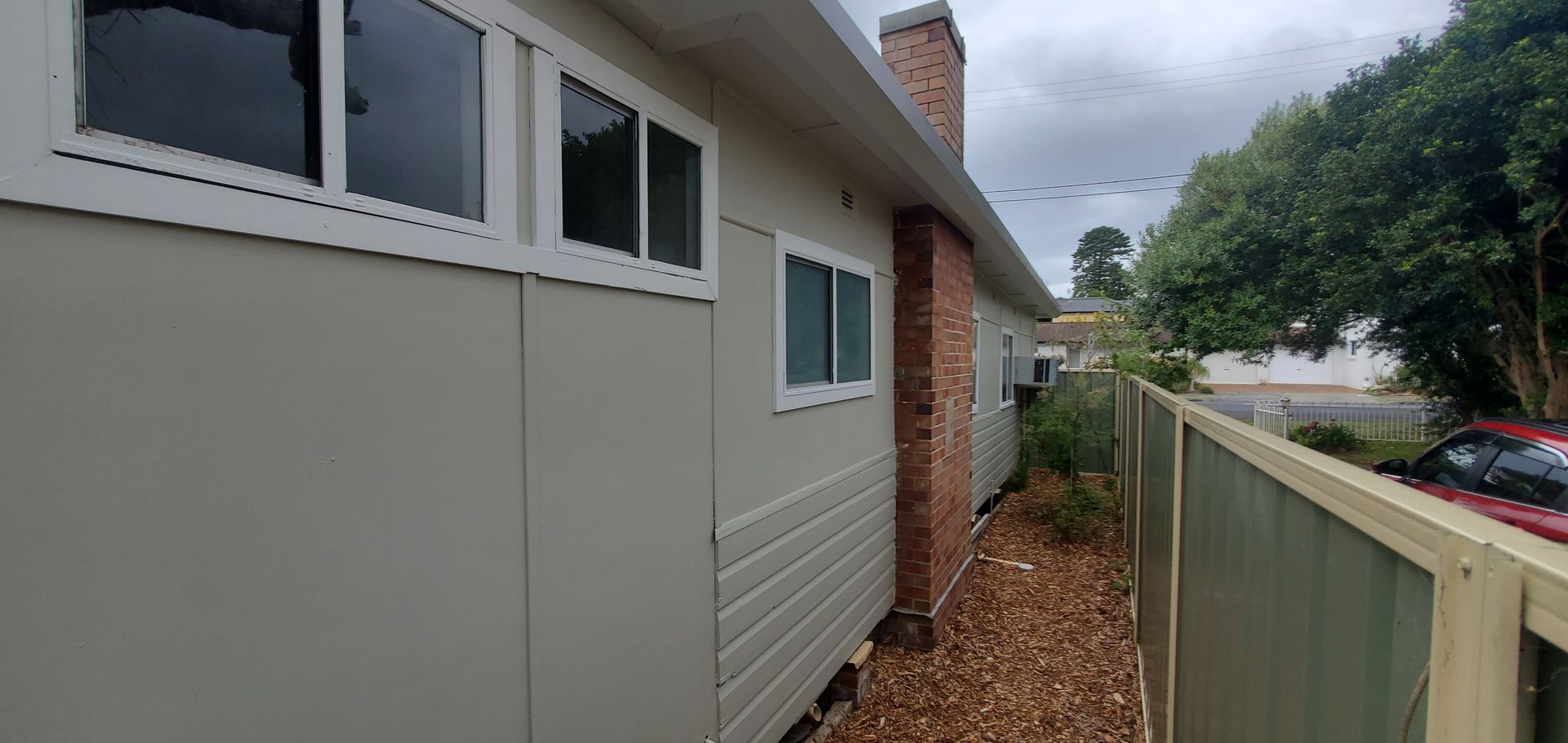 A house with a fence in front of it and a lot of windows — JWP Painting & Property Services in Ettalong Beach, NSW