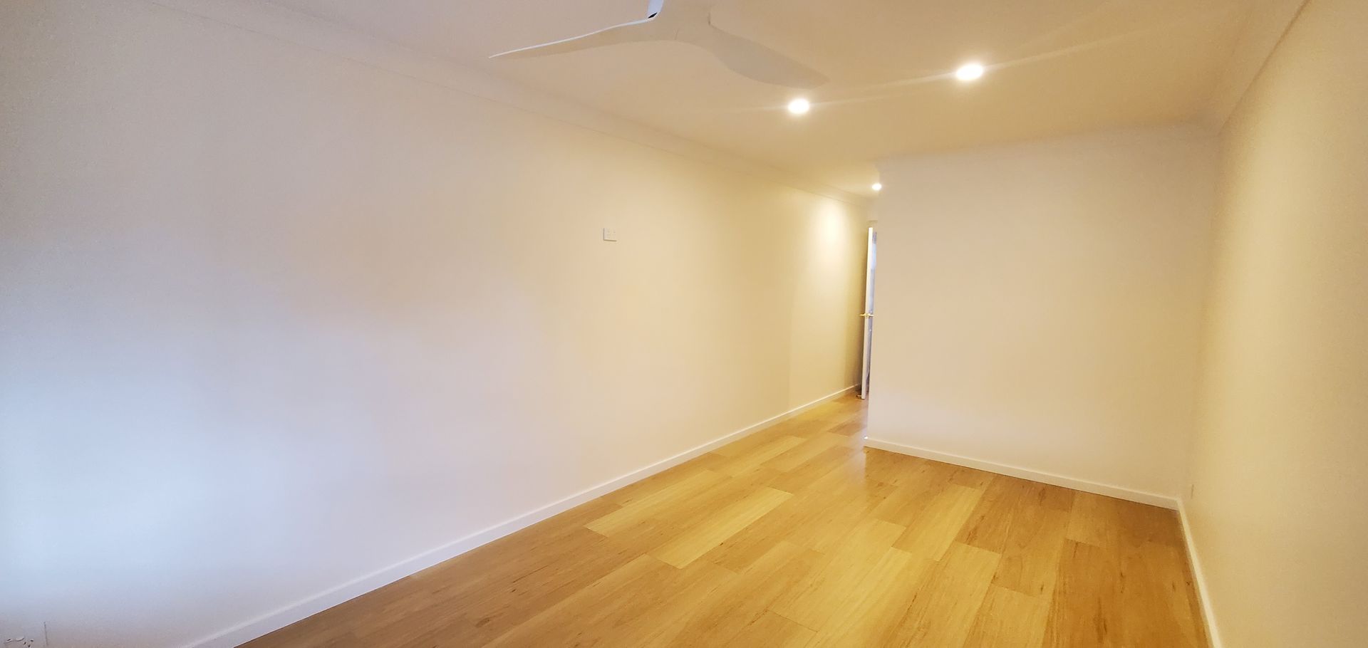 An empty room with hardwood floors and white walls — JWP Painting & Property Services in Ettalong Beach, NSW