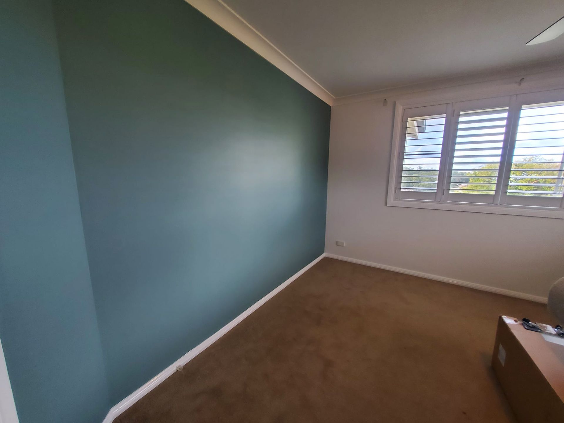 A room with a blue wall and a window — JWP Painting & Property Services in Ettalong Beach, NSW