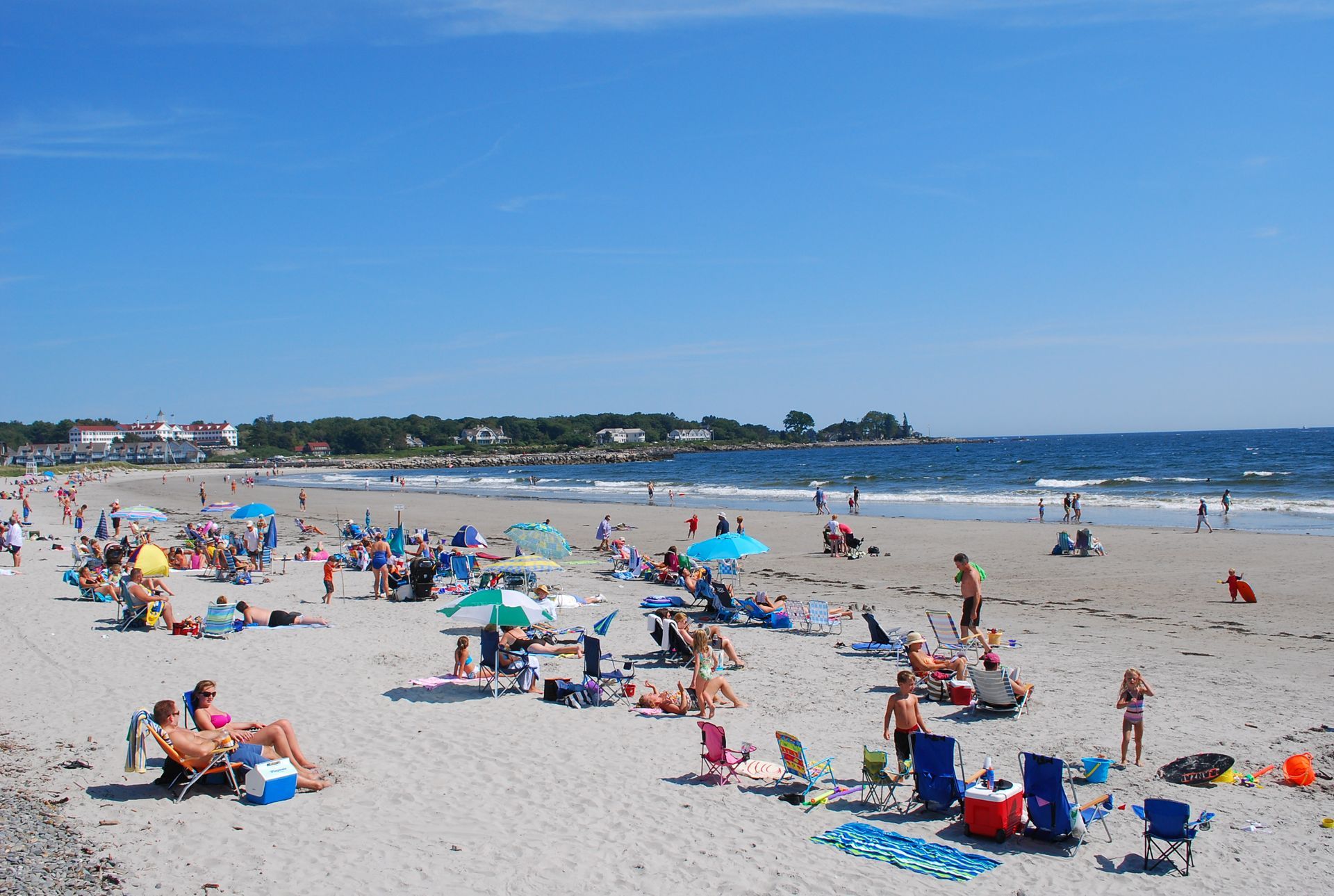 A beach filled with people and umbrellas on a sunny day