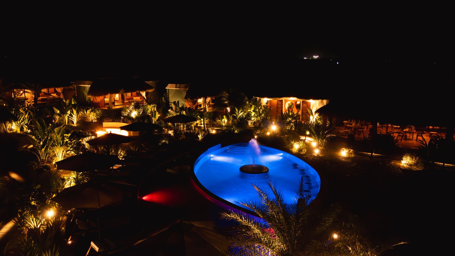 Una gran piscina está iluminada por la noche.