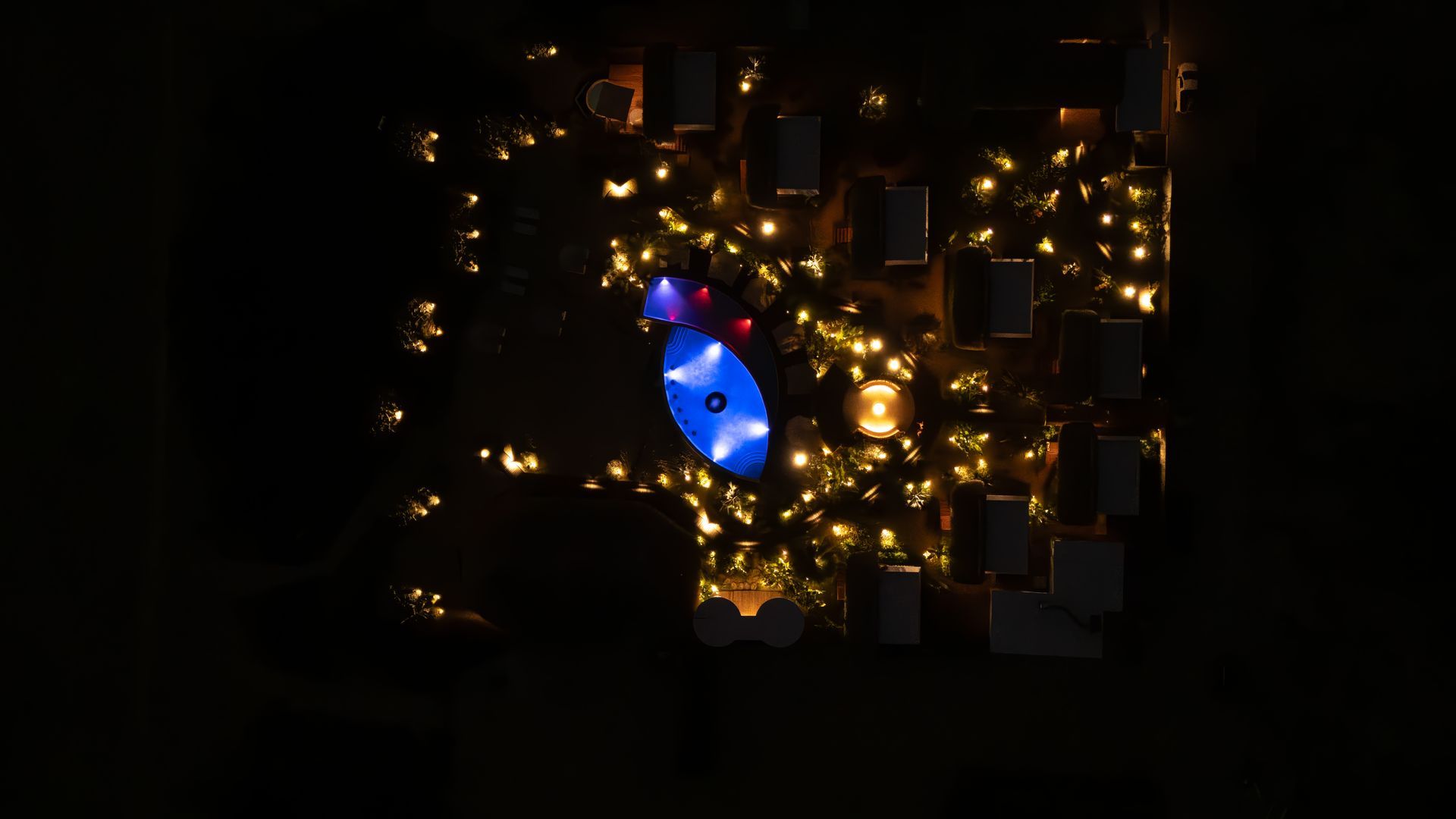 Una vista aérea de un árbol de Navidad decorado con luces por la noche.