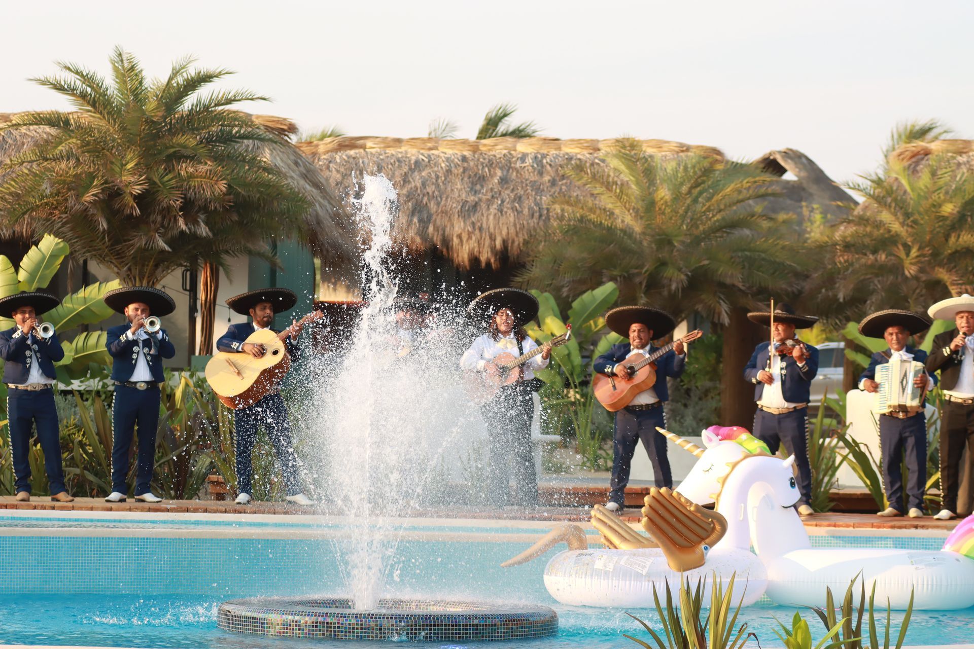 Un grupo de mariachis tocan frente a una fuente.