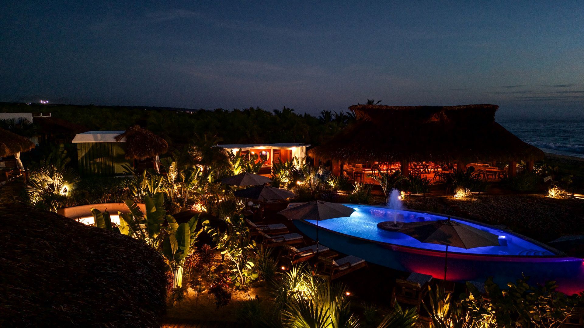 Una gran piscina está iluminada por la noche.