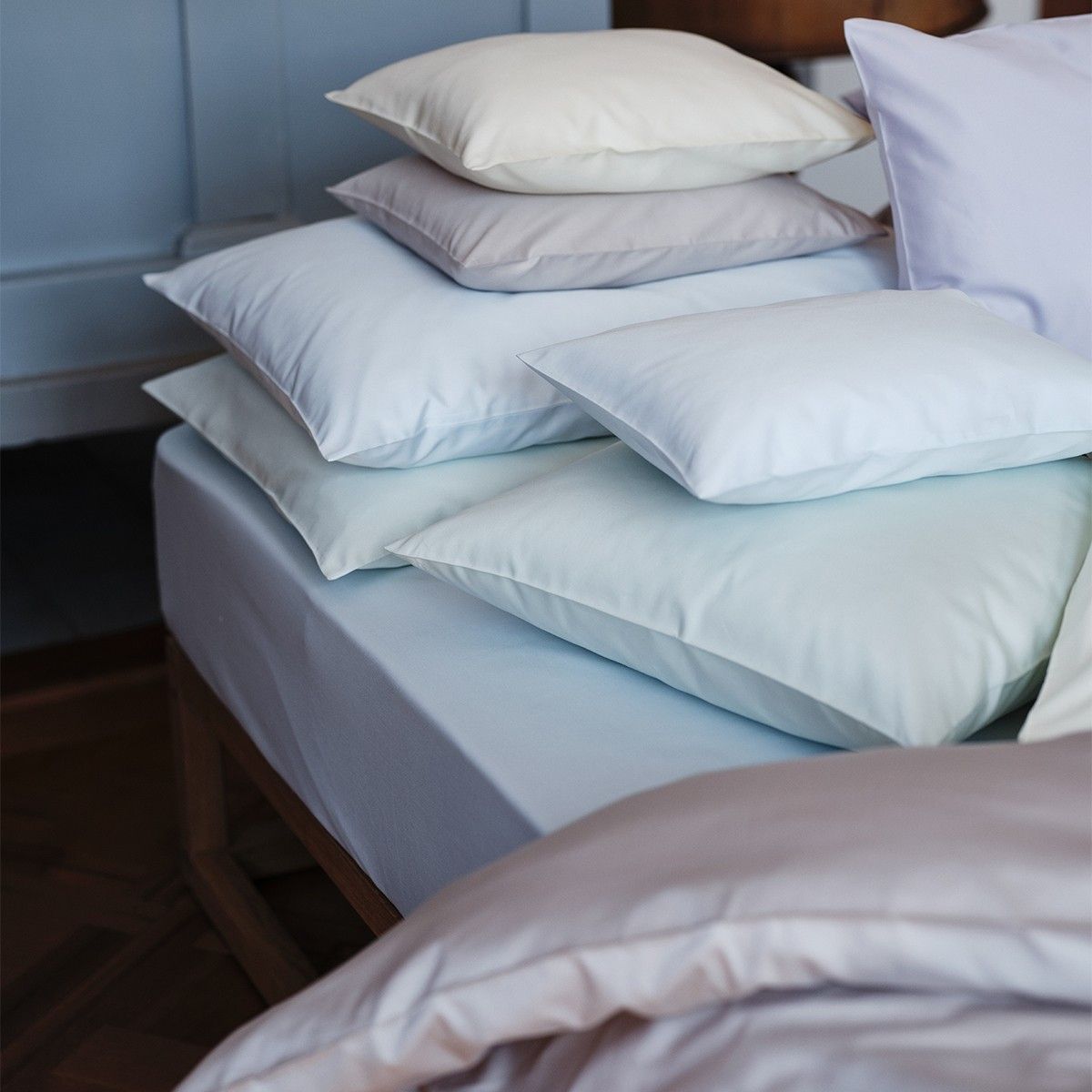 White pillows are stacked on top of each other on a bed