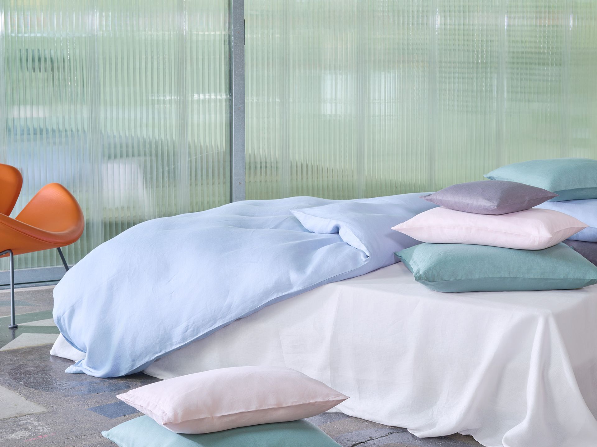A bed with a blue comforter and pillows on it.