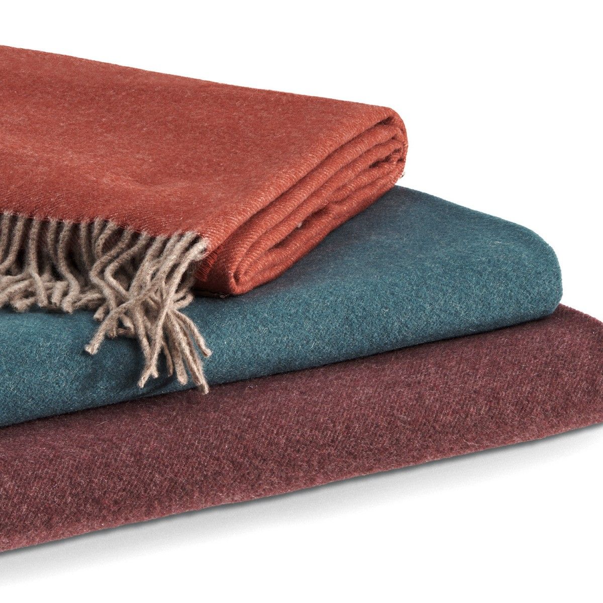 Three blankets of different colors are stacked on top of each other.