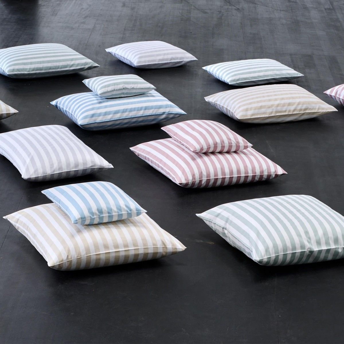 A bunch of striped pillows are laying on the floor