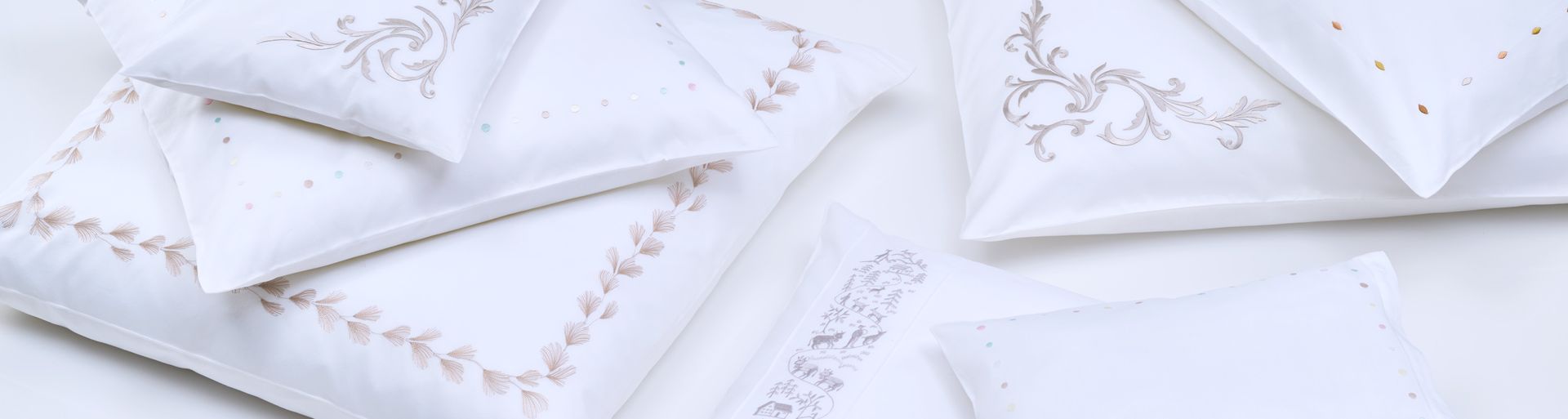A bunch of white pillows sitting on top of each other on a table.