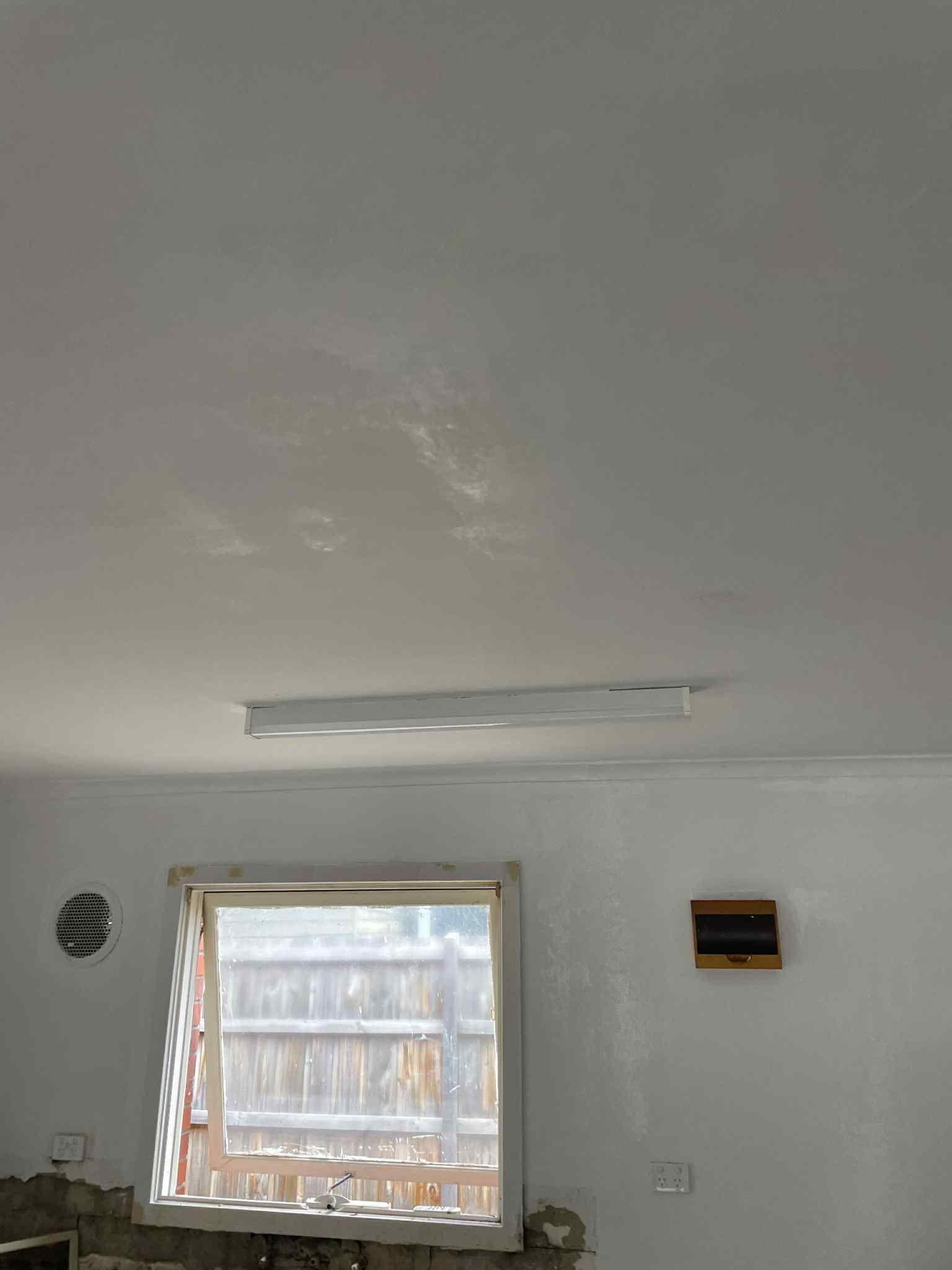 Electrician installing recessed downlights in living room