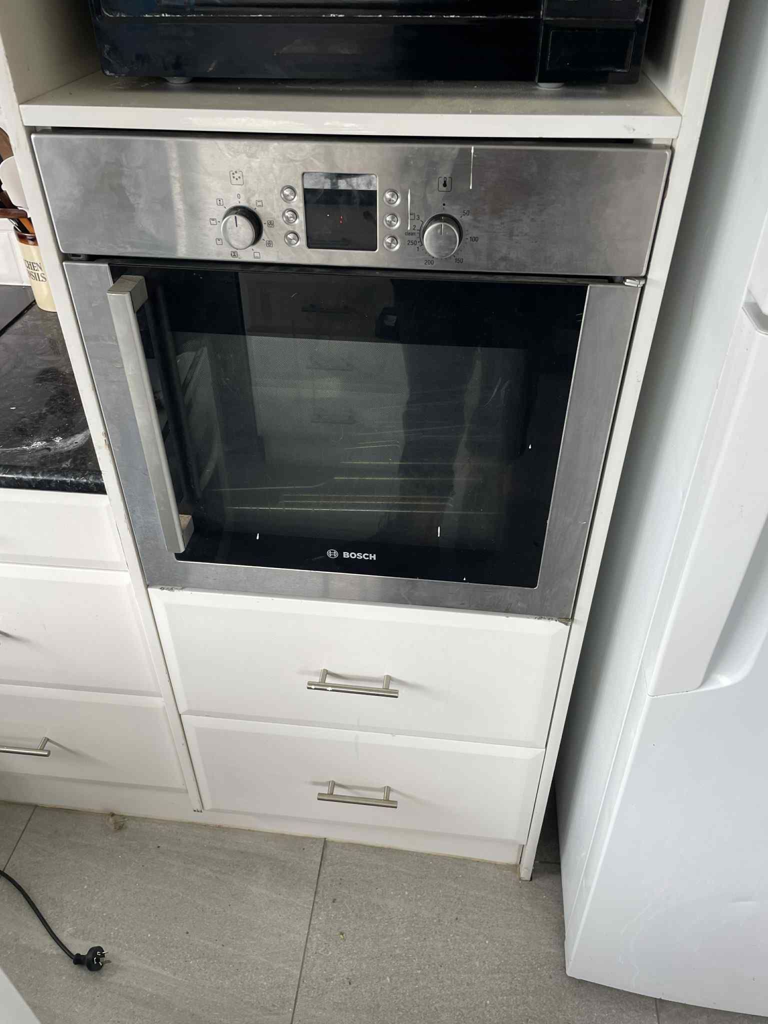 Under-bench oven installation with power outlet concealed behind unit