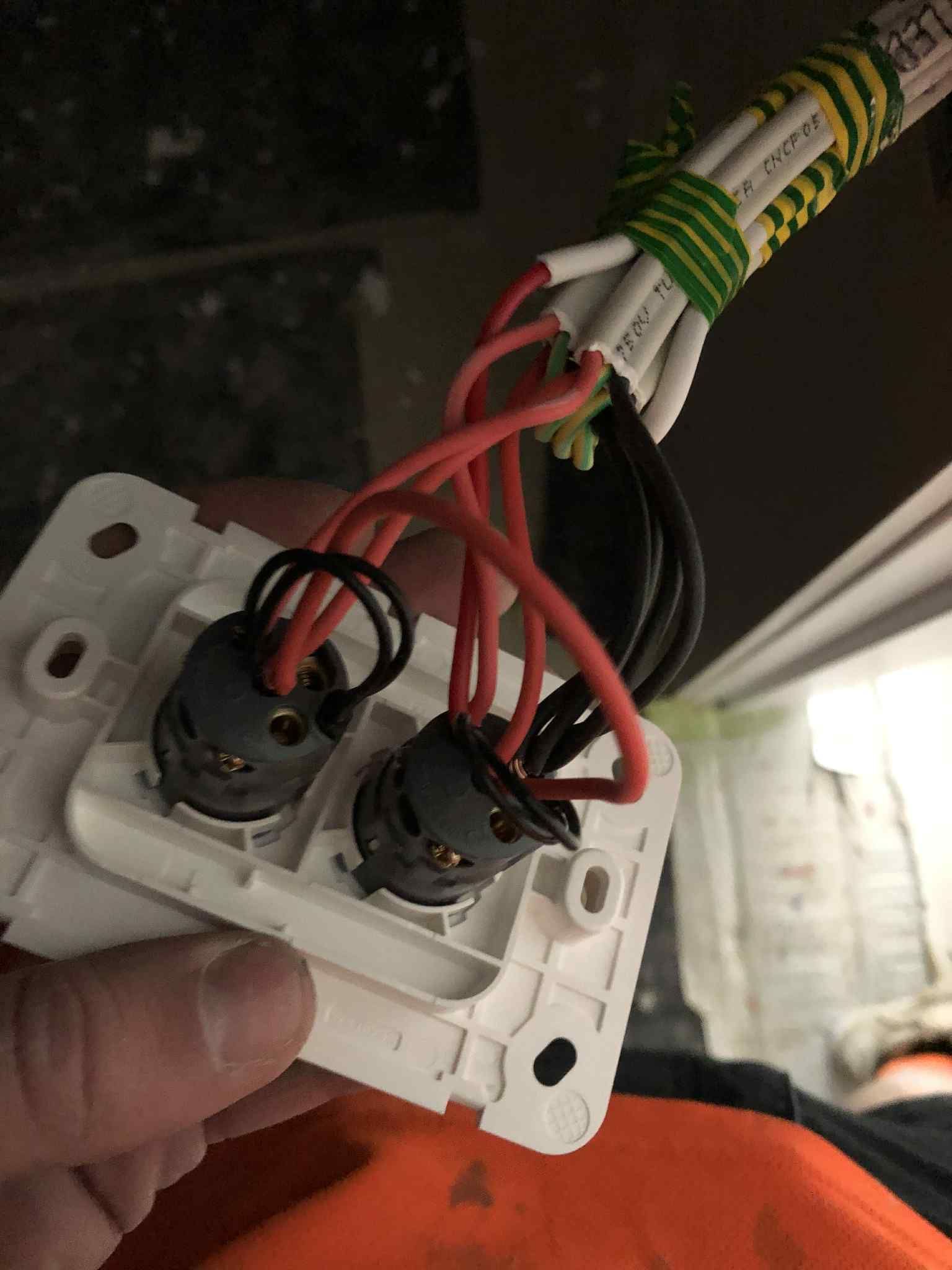 Close-up dual-gang switch wiring with red and black conductors during electrical installation in Melbourne.