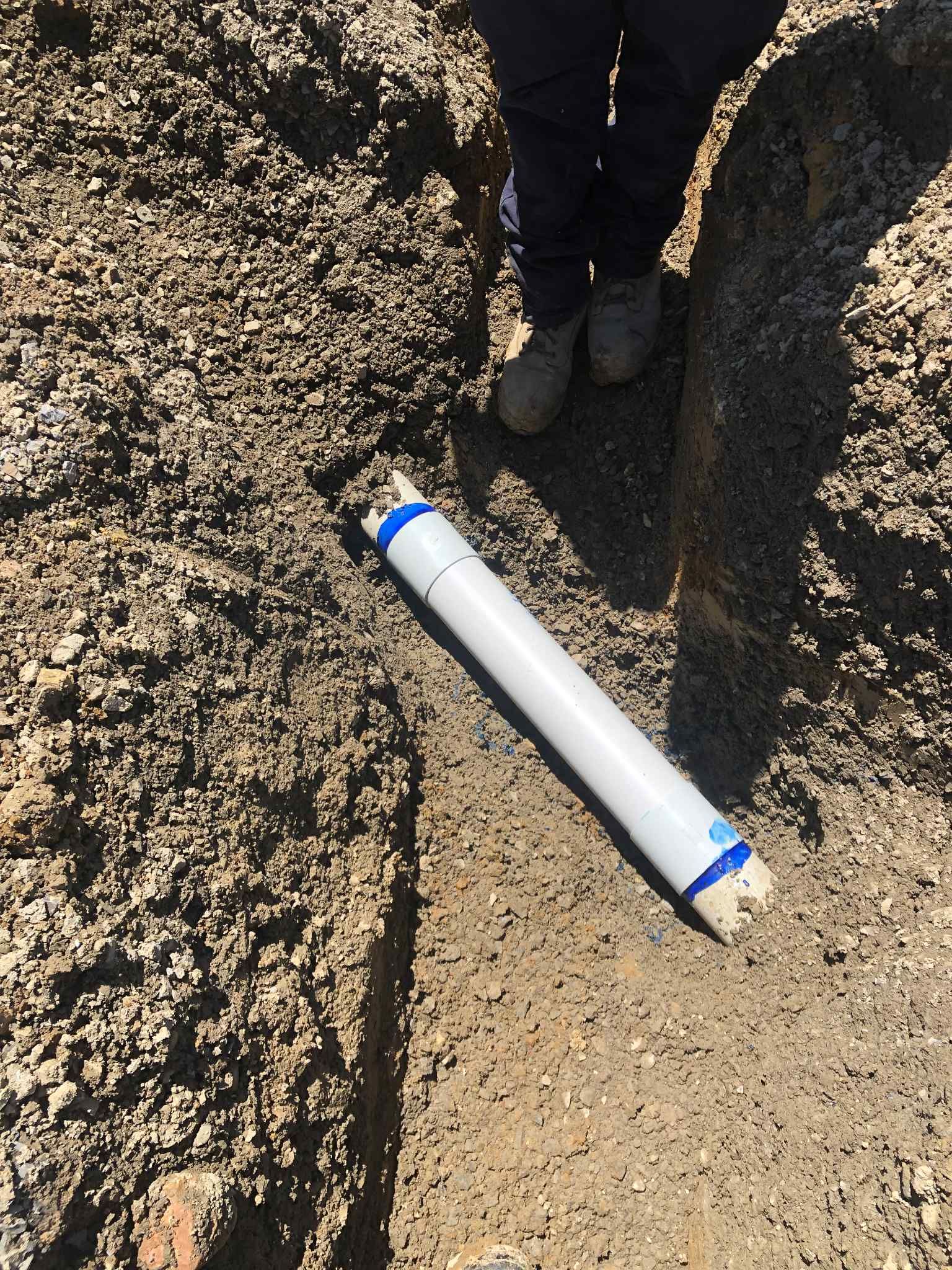 White PVC conduit in trench ready for underground power installation in Hampton