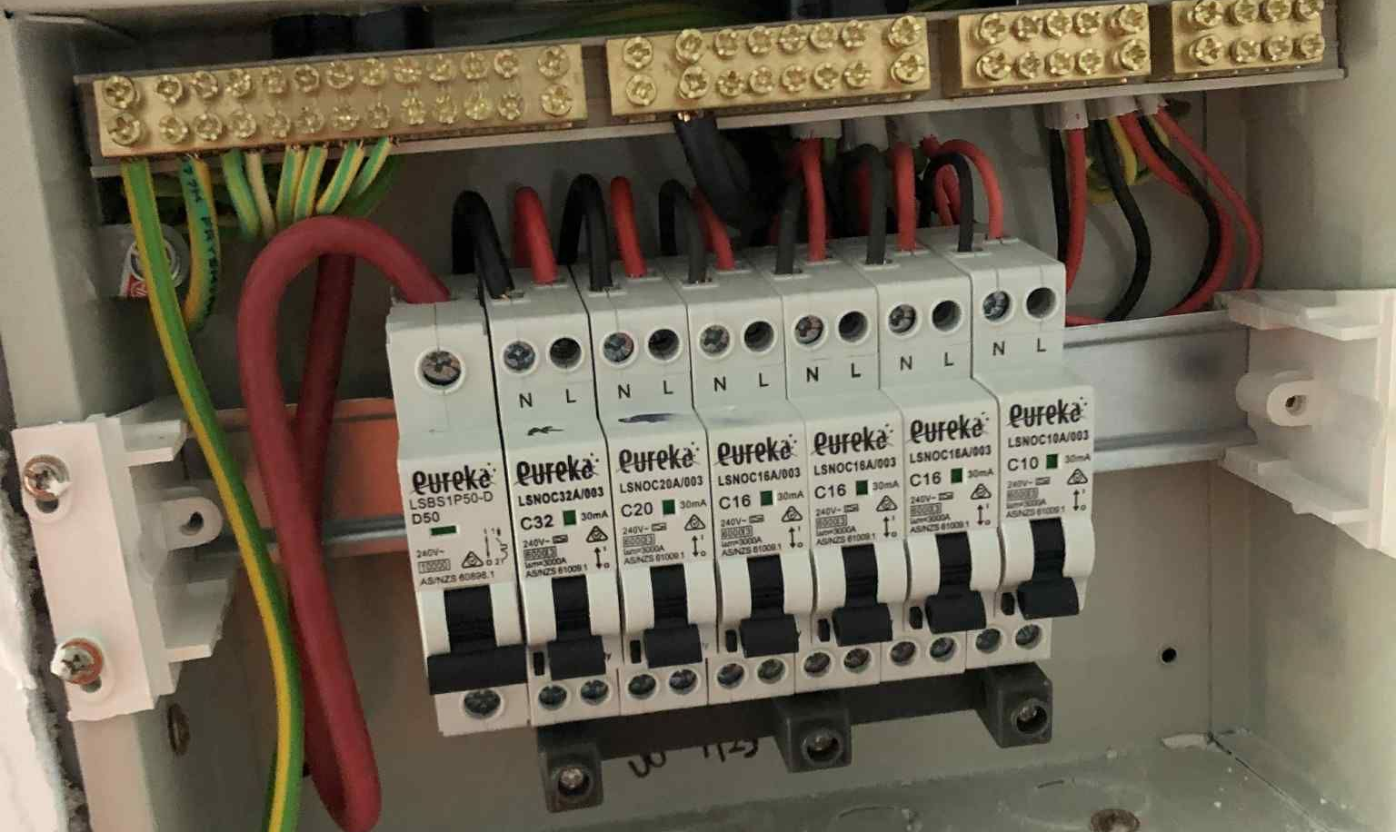 Switchboard consumer unit with Eureka RCDs/MCBs (C32, C20, C16, C10), earth & neutral bars visible —