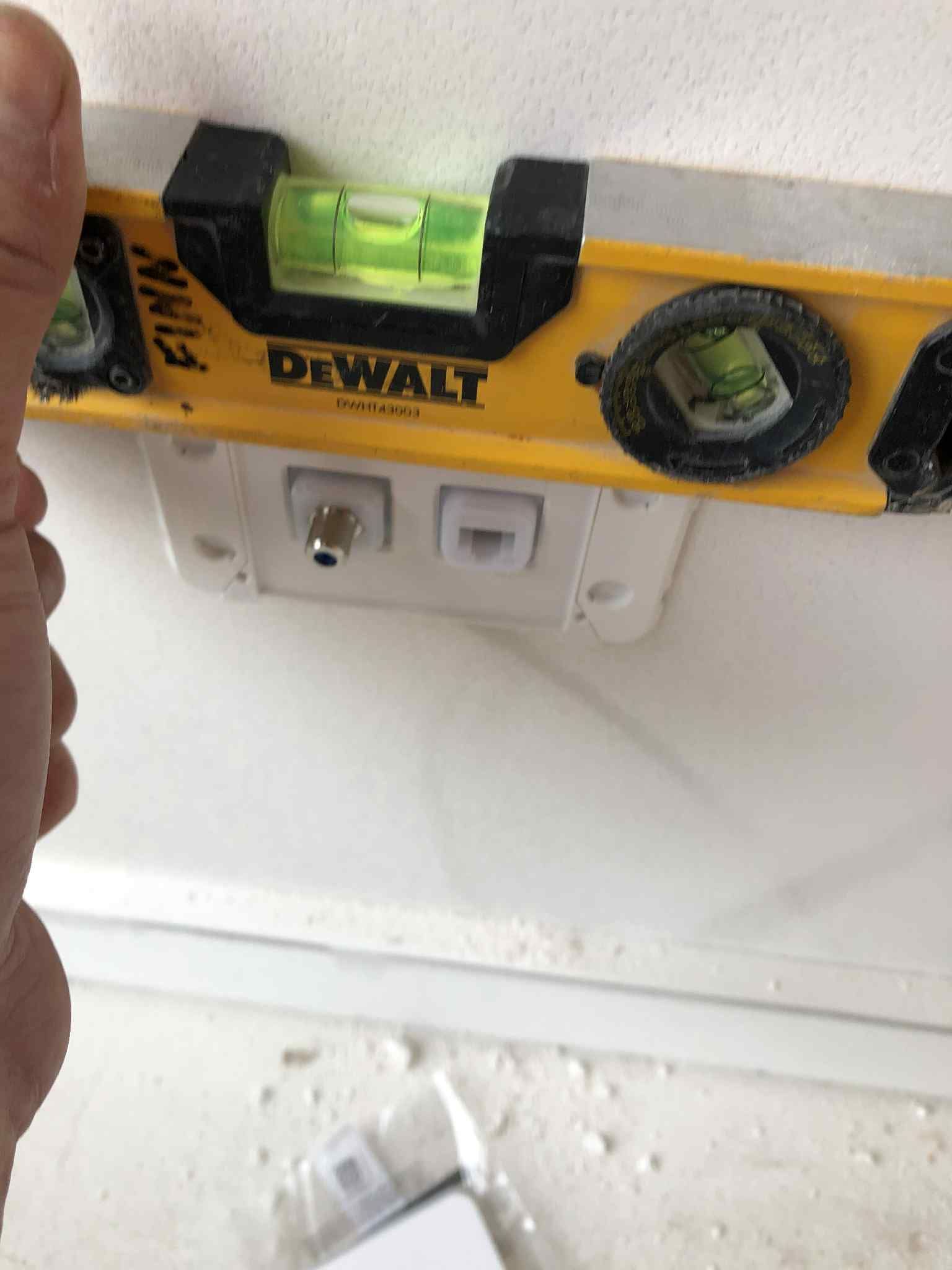 Double power point being levelled and installed under a benchtop during kitchen electrical fit-out in Melbourne.