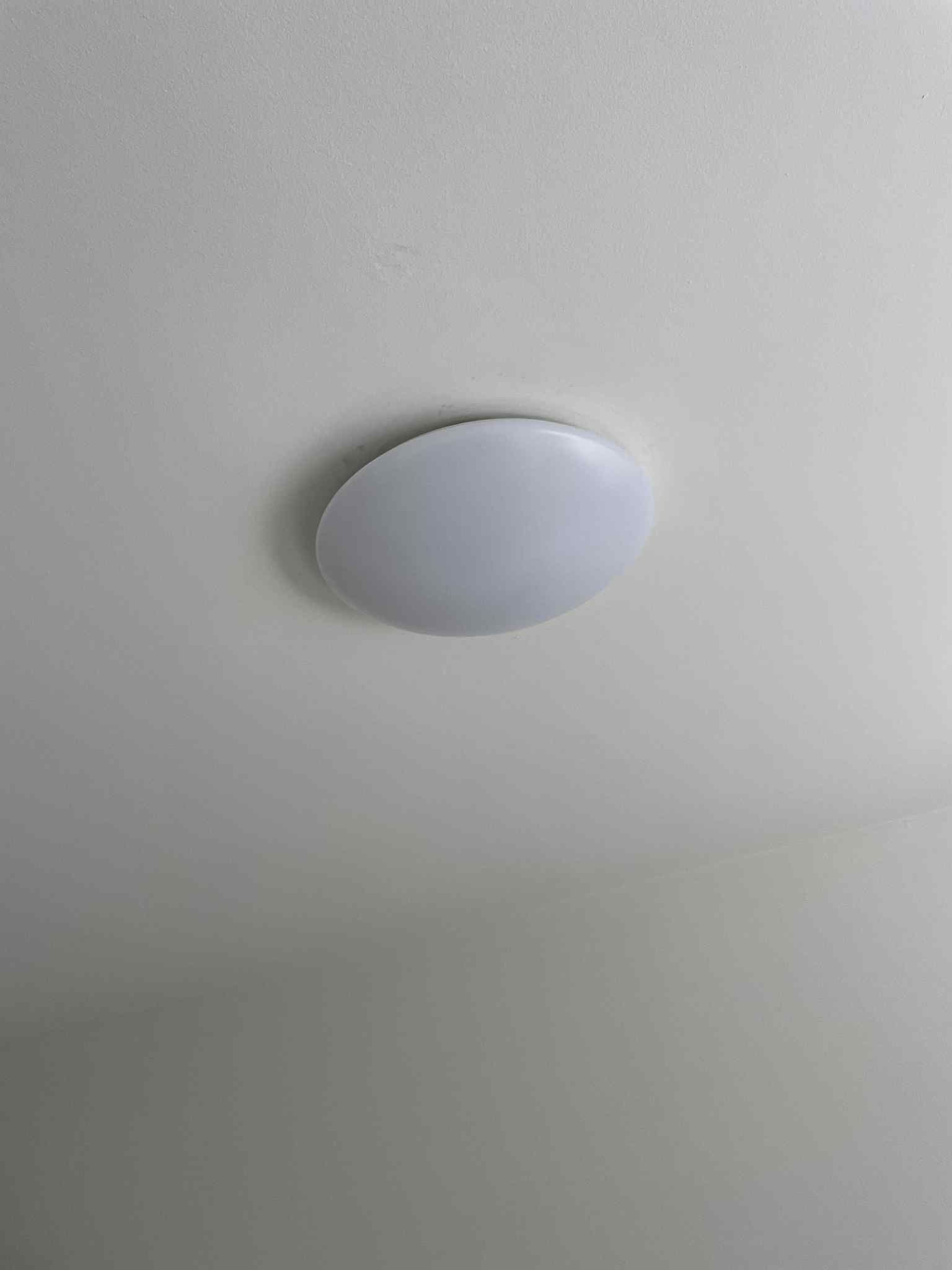 Licensed electrician fitting pendant light over kitchen bench