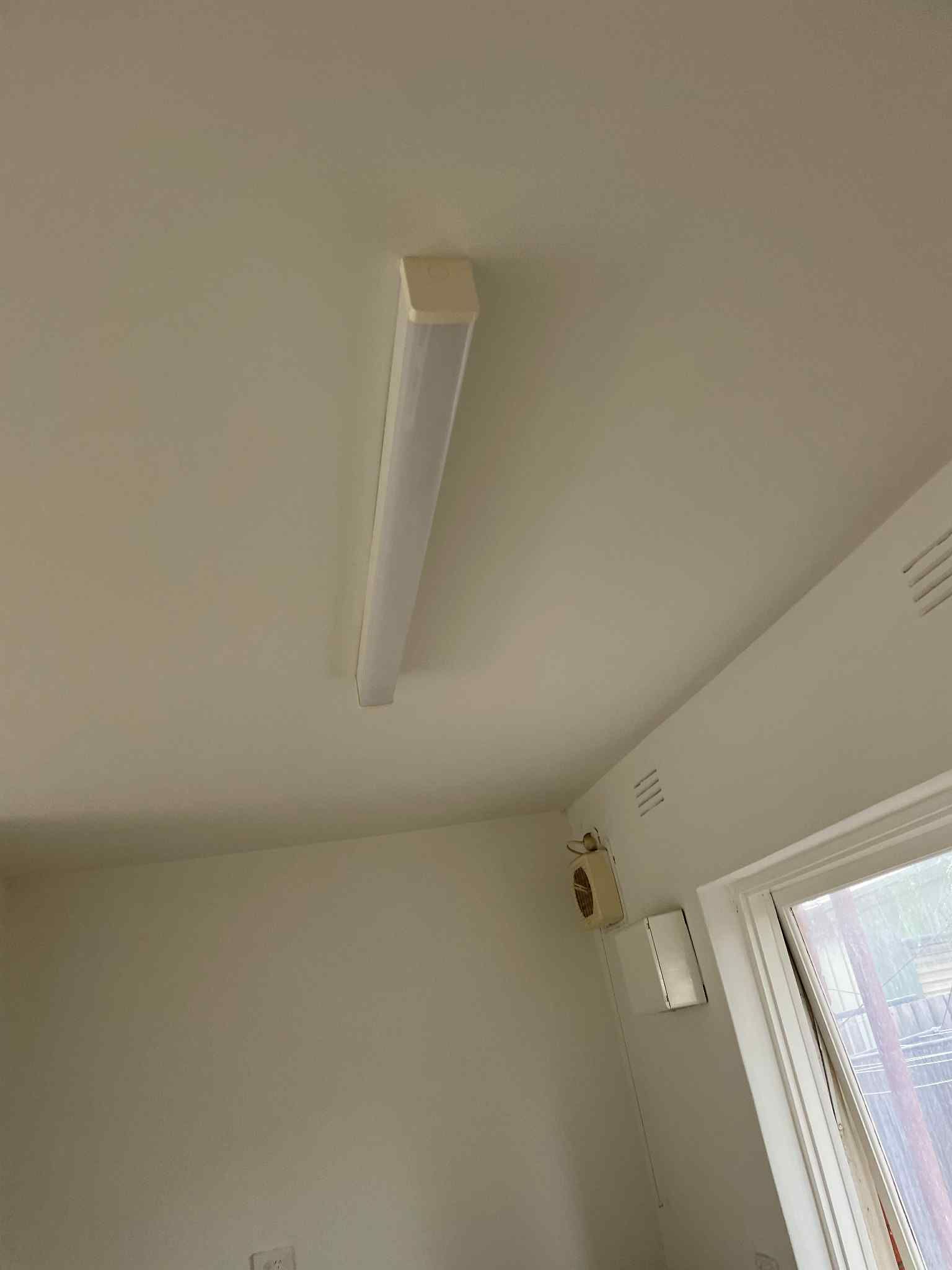 Electrician installing LED downlight in residential ceiling — Ziesing Electrical