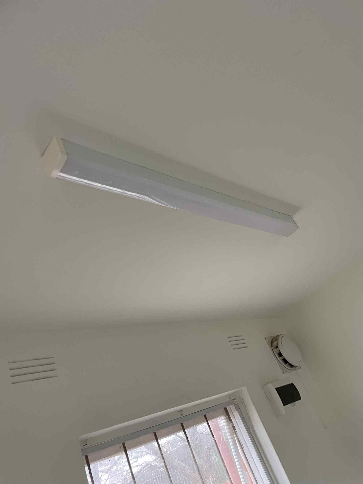 Electrician installing LED downlight in Melbourne kitchen — Ziesing Electrical