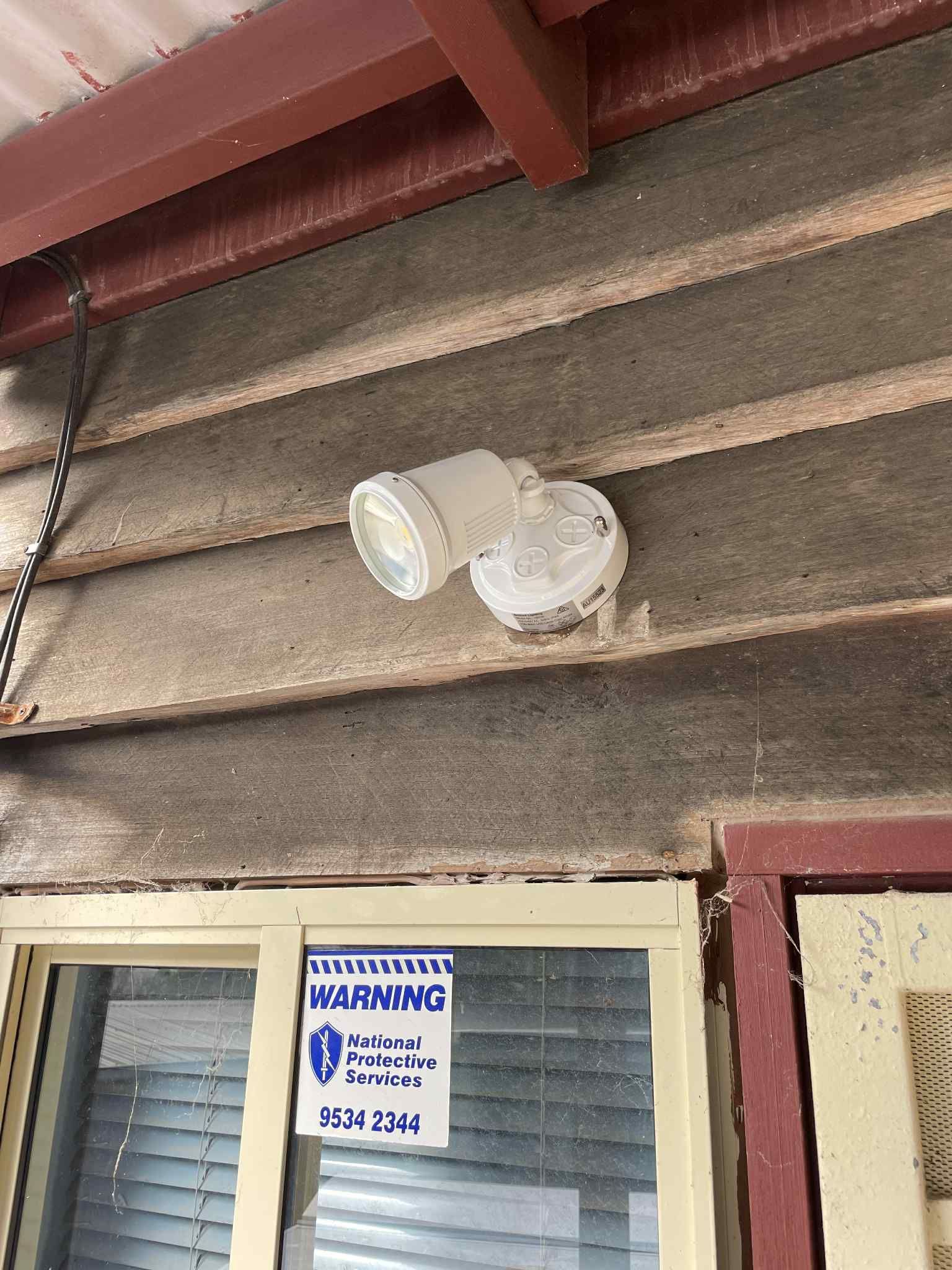 Electrician mounting garage LED floodlight in Bayside — Ziesing Electrical