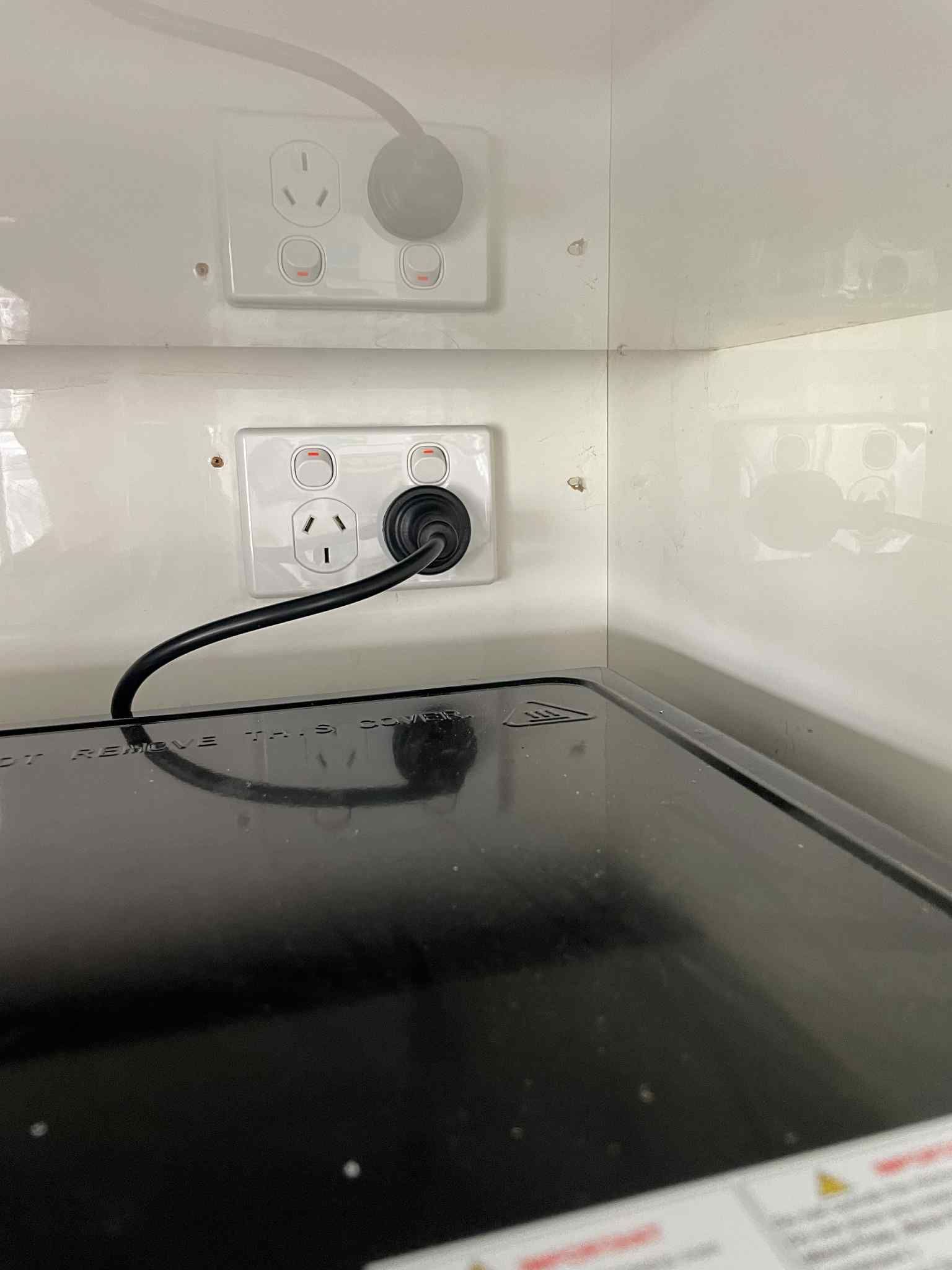 Labelled switches on kitchenette wall for lights and oven