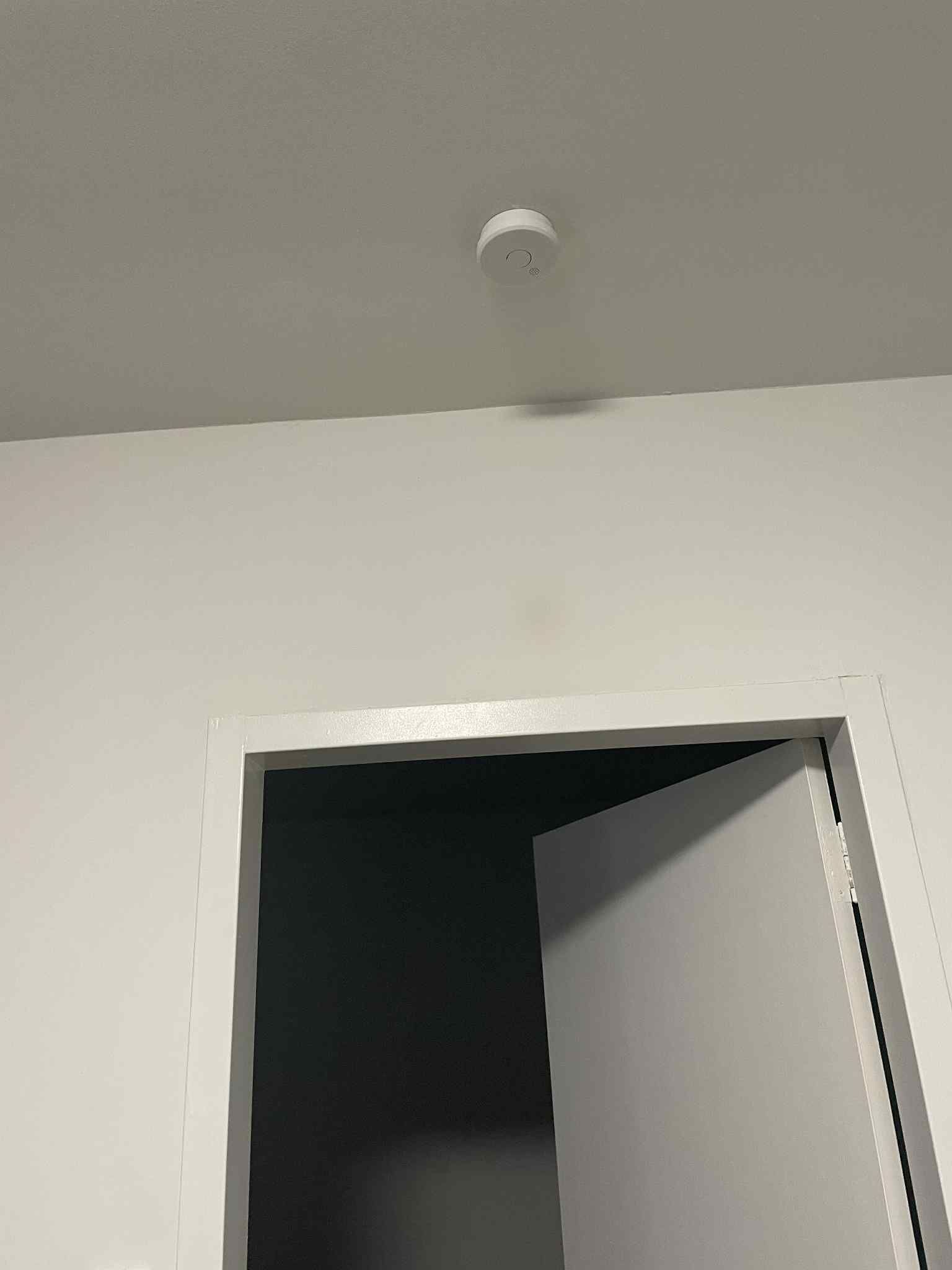 Electrician wiring new interconnected smoke alarms in home