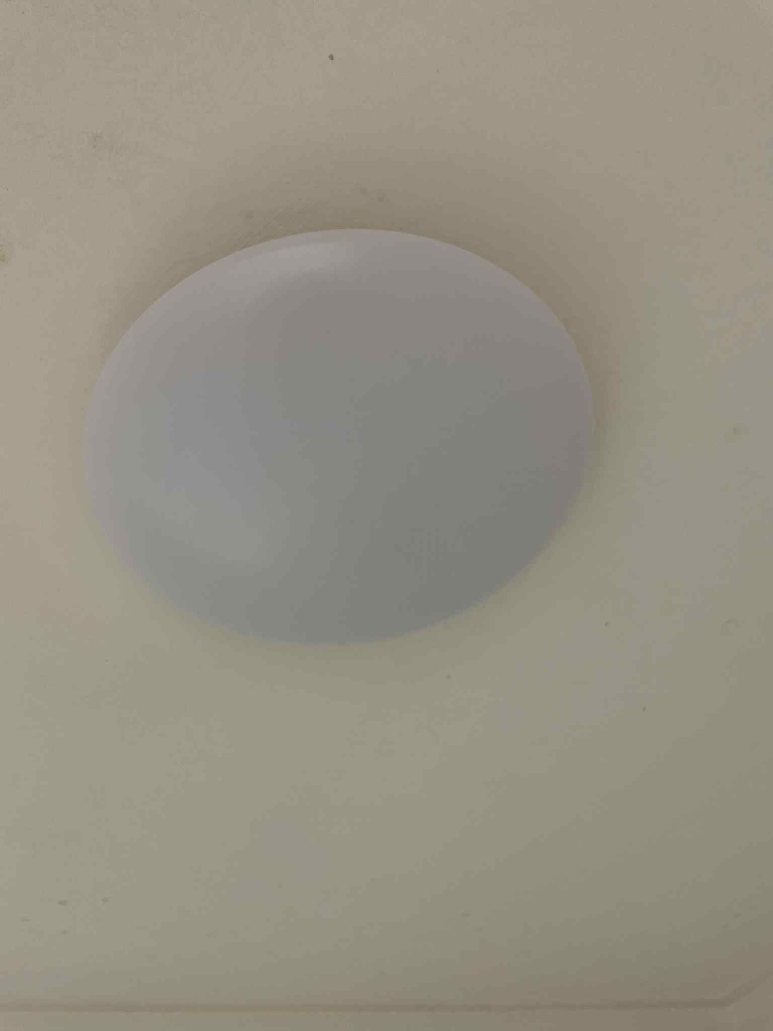 Electrician adjusting recessed spotlight trim during install