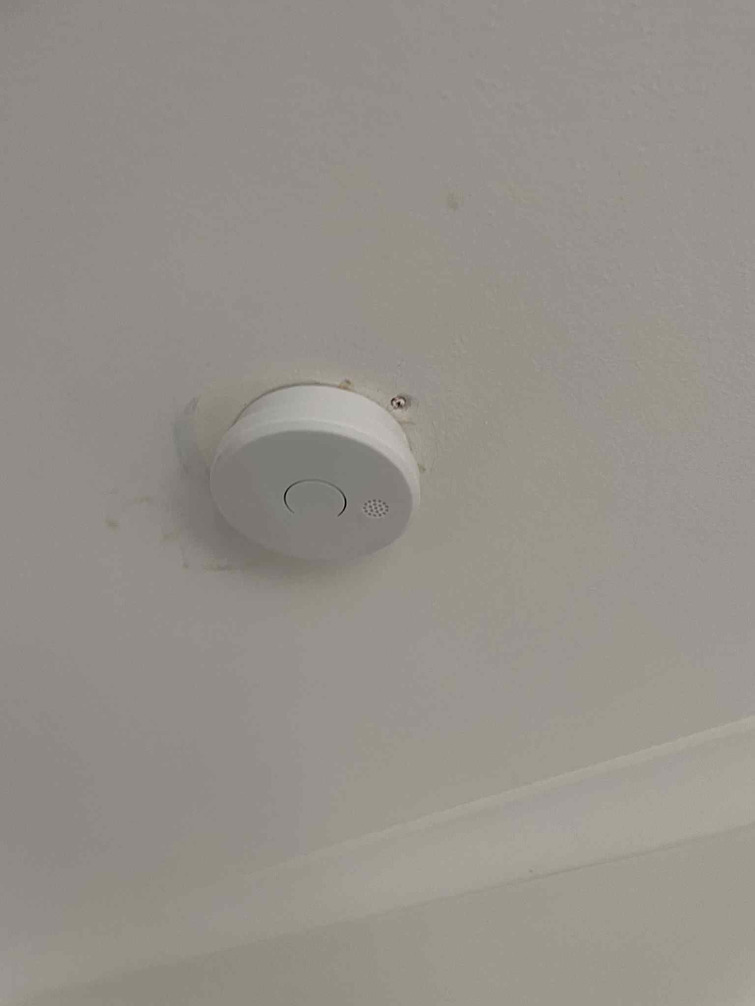 Ceiling-mounted smoke detector installed during electrical safety inspection