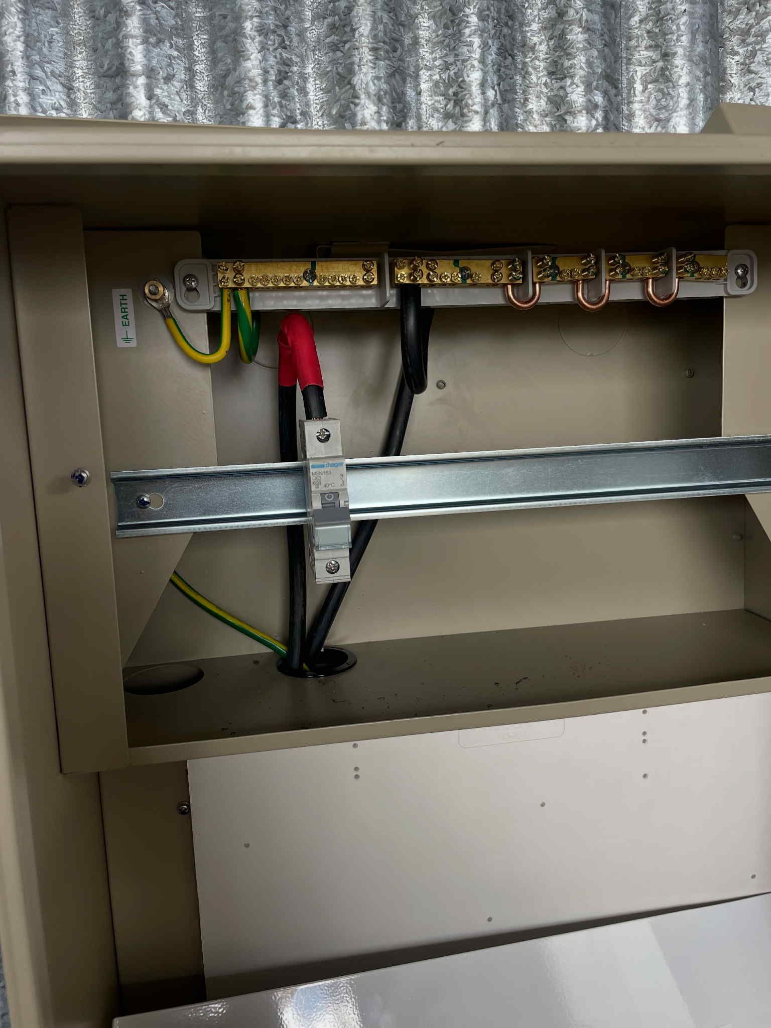 Colour-coded electrical wires emerging from junction box