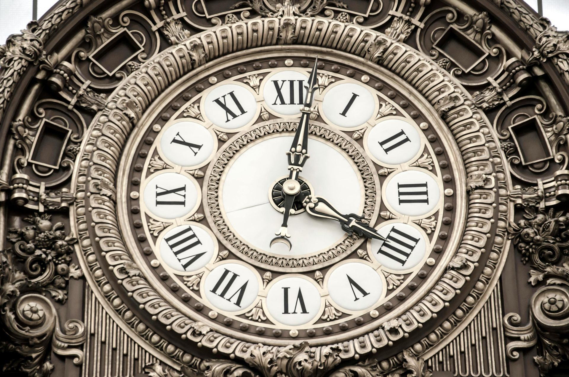 An ornate, vintage clock face with Roman numerals showing the time at approximately 12:22.