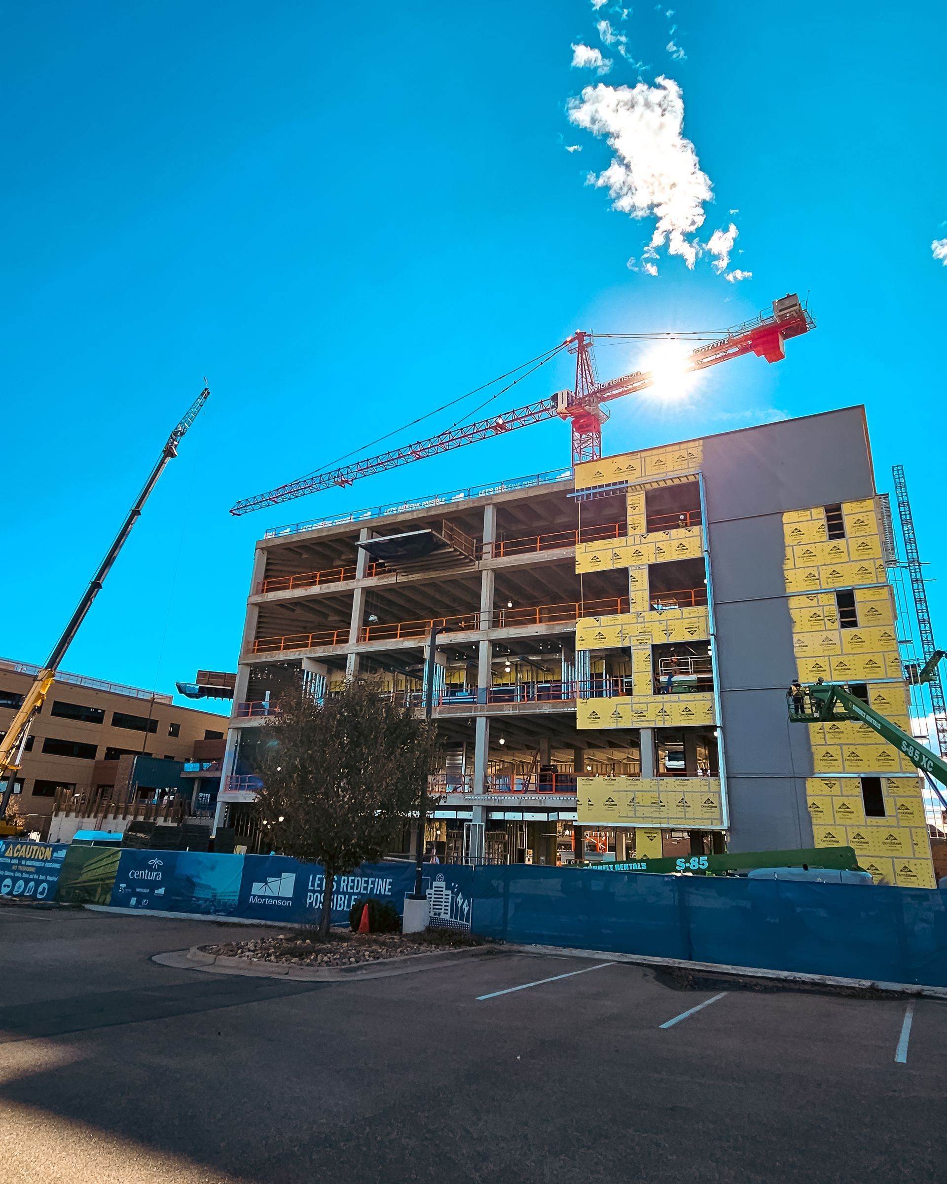 A large building under construction with a crane on top of it