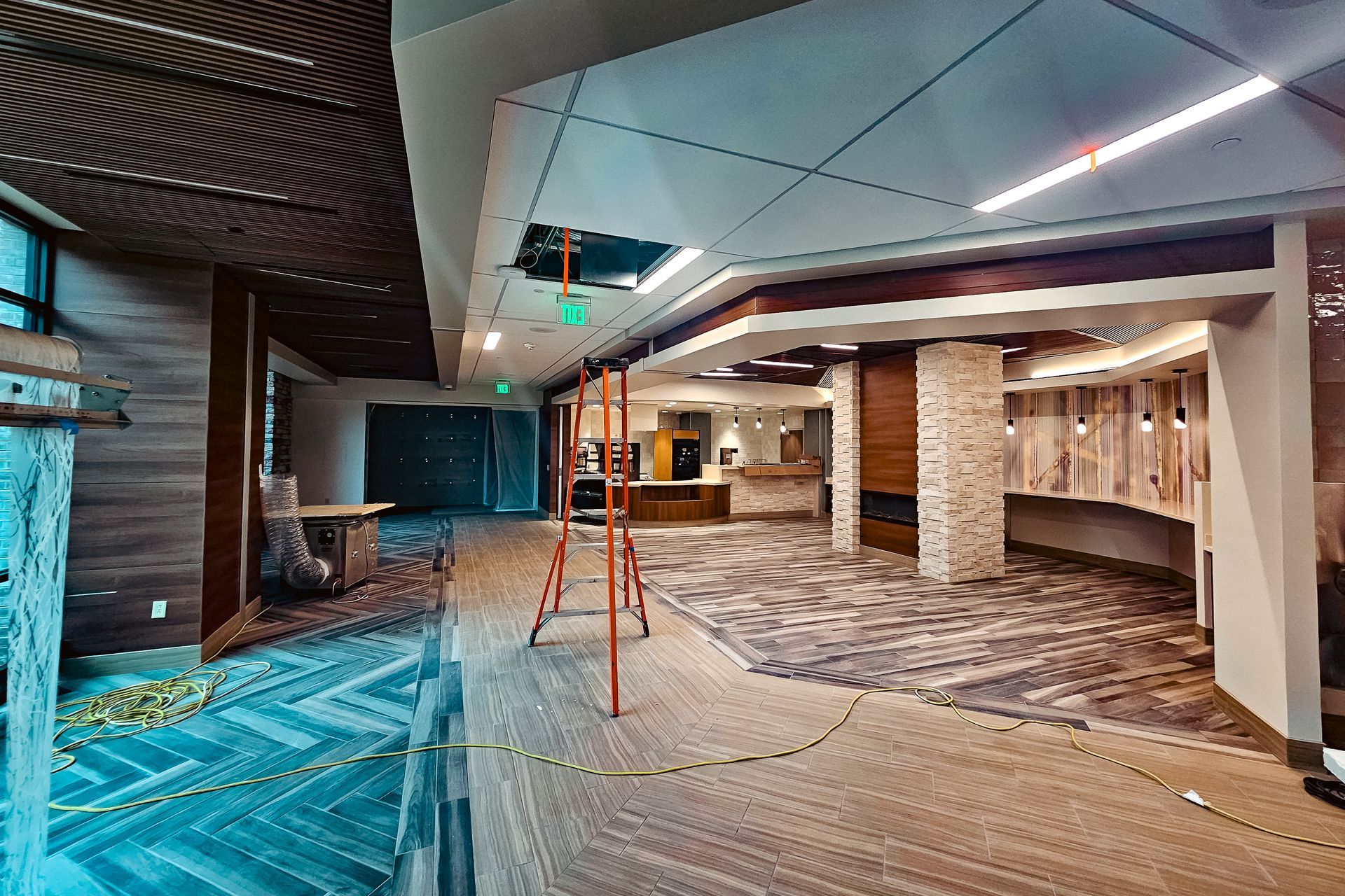 A large empty room with a ladder in the middle of it.