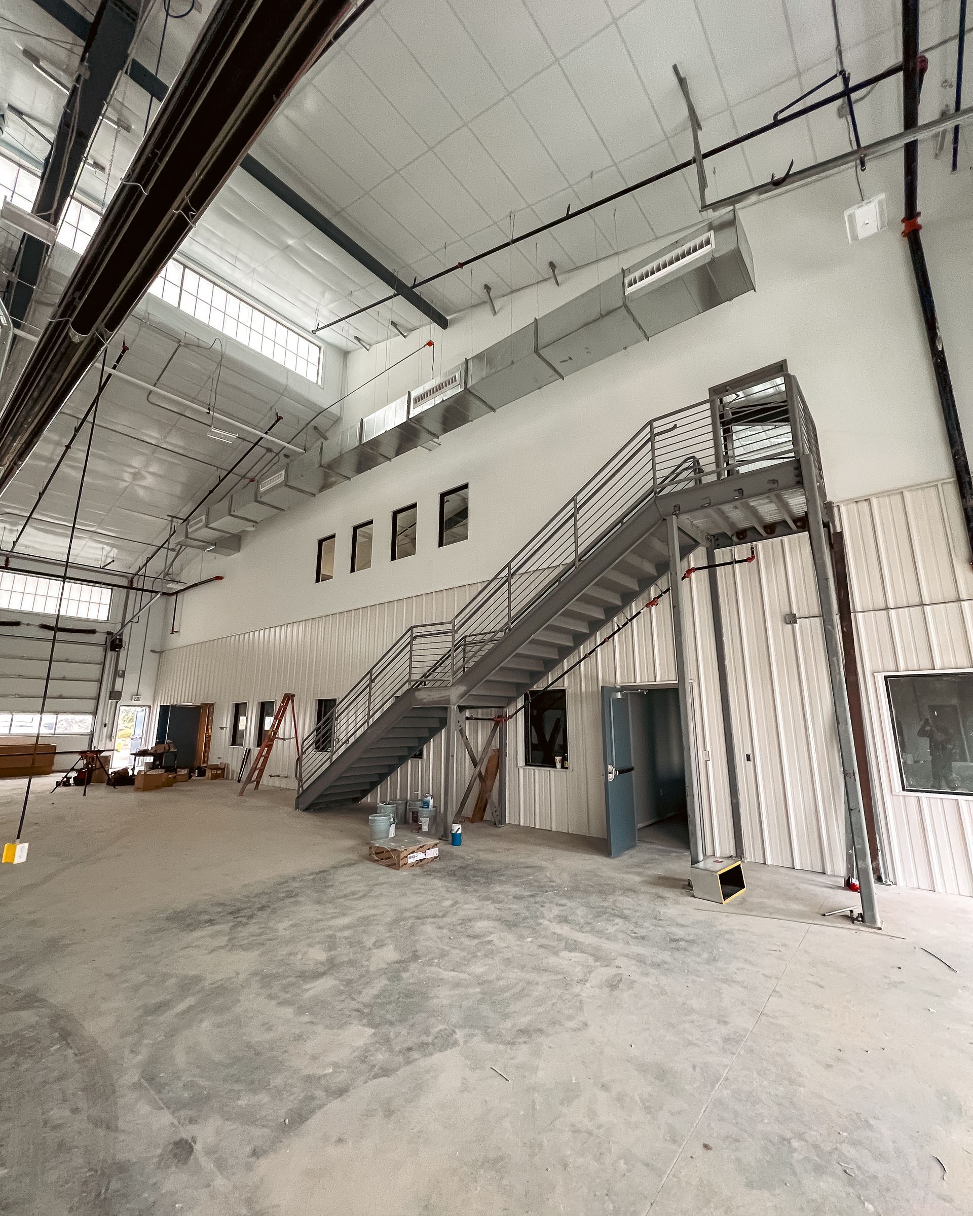 A large warehouse with stairs leading up to the second floor
