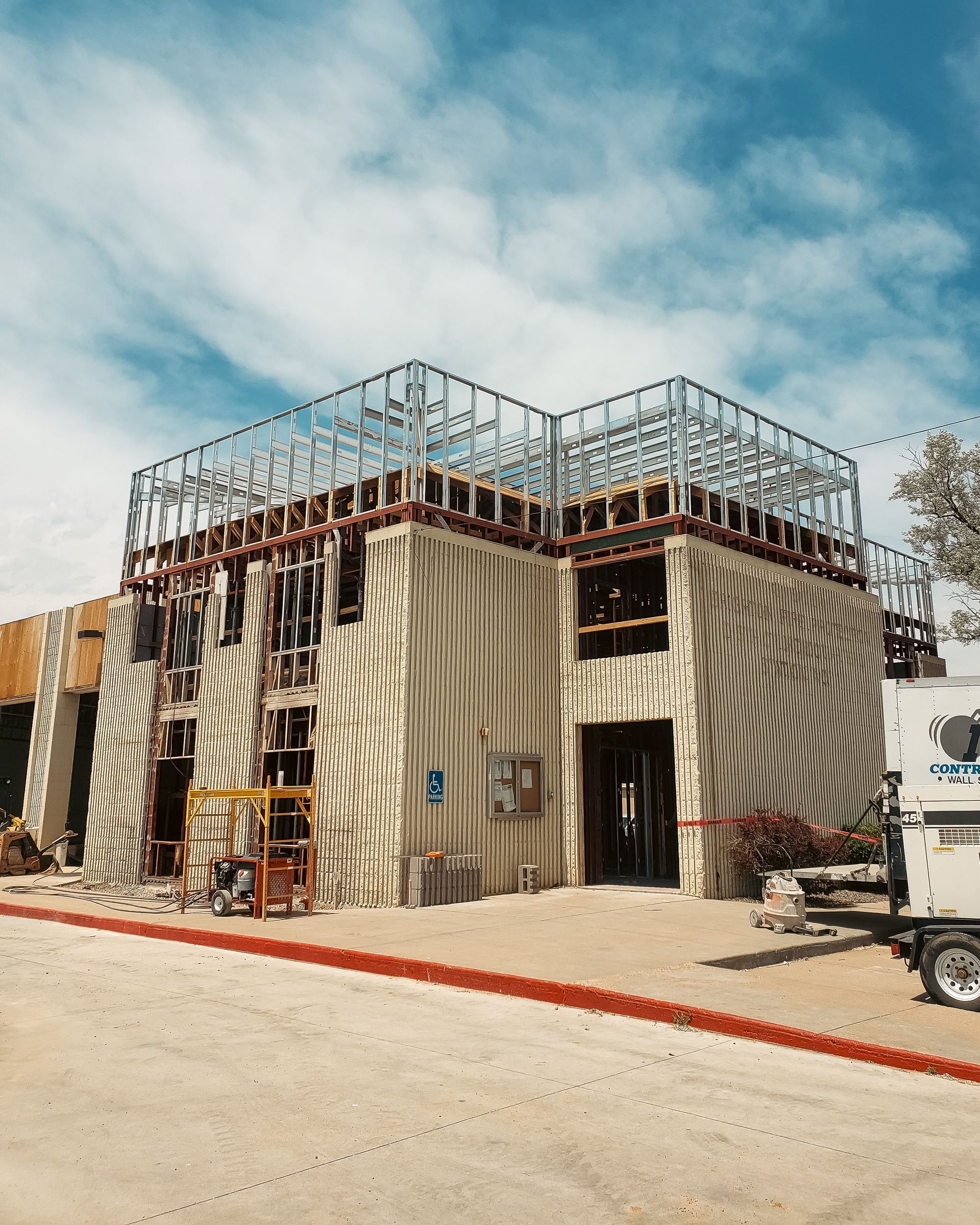 A large building under construction with a metal frame on top