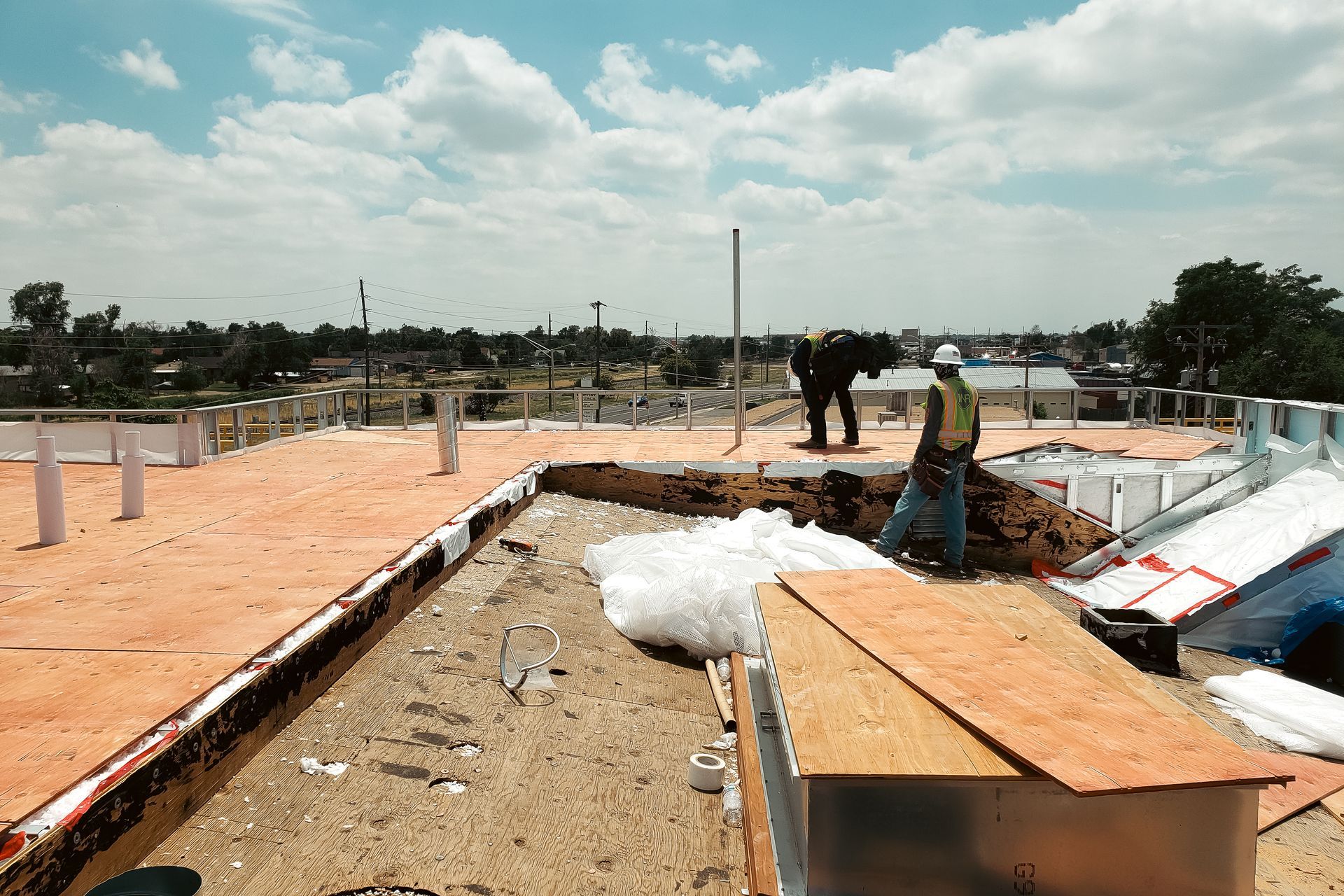 Construction workers are working on the roof of a building