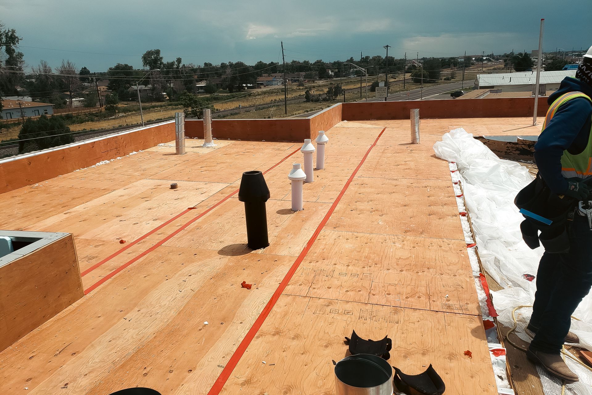 A man is standing on top of a wooden roof.