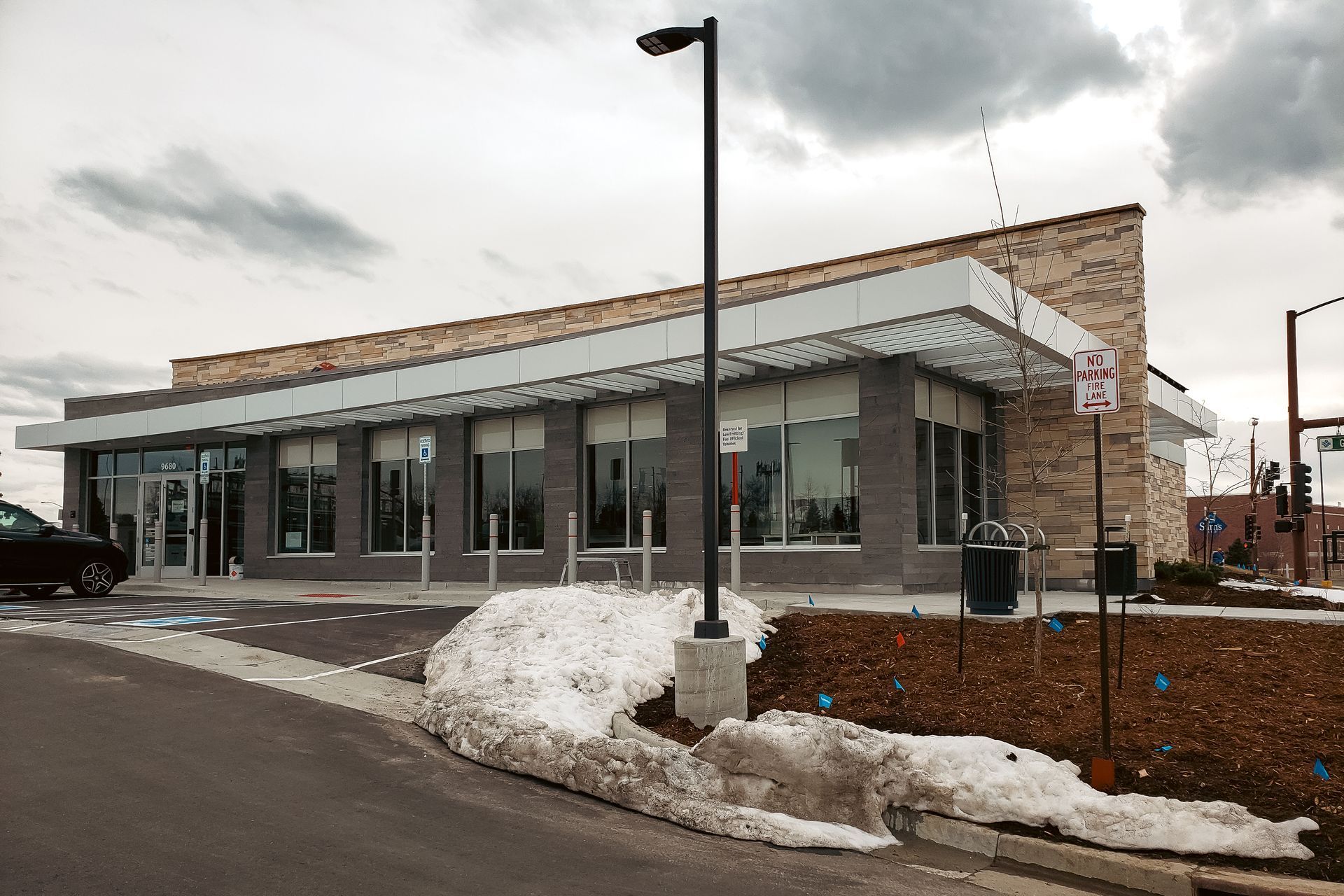 A large building with a lot of windows and a parking lot in front of it.