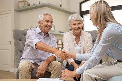 Elder Law — Senior Couple Shaking Hands with Financial Advisor in Miami Lakes, FL