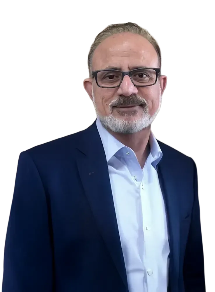 Mayur Dubai in a suit smiles, looking at the viewer. He has a beard and is against a transparent background.