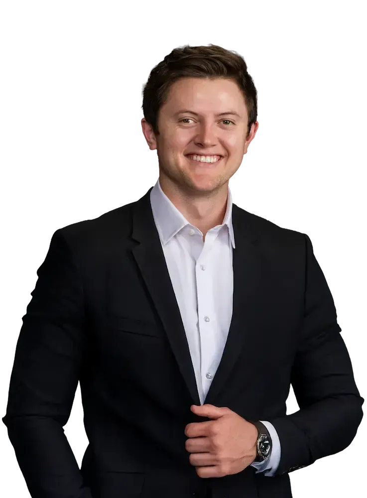 Parker Paulsen Parker Paulsen in a suit smiling, looking at the viewer. He is against a tansparent background.