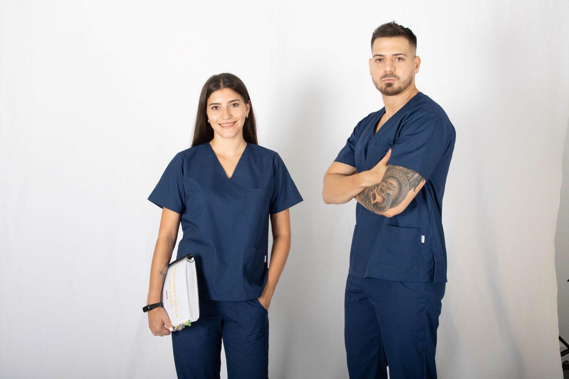 Un hombre y una mujer vestidos con uniforme médico están parados uno al lado del otro.