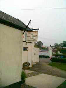 A white building with a sign on the side of it.