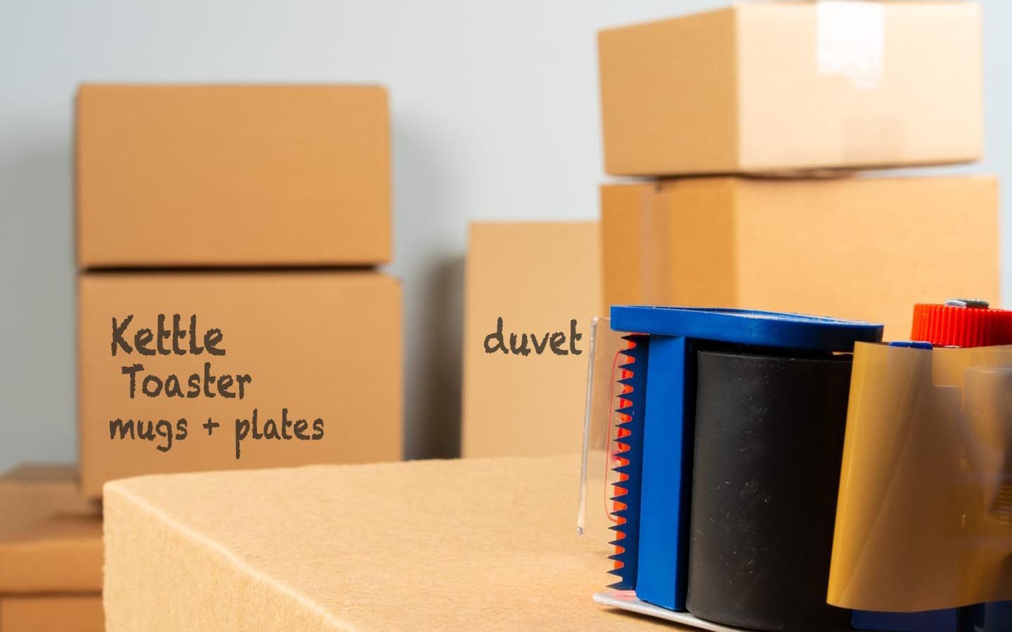 A stack of cardboard boxes with one labeled kettle toaster