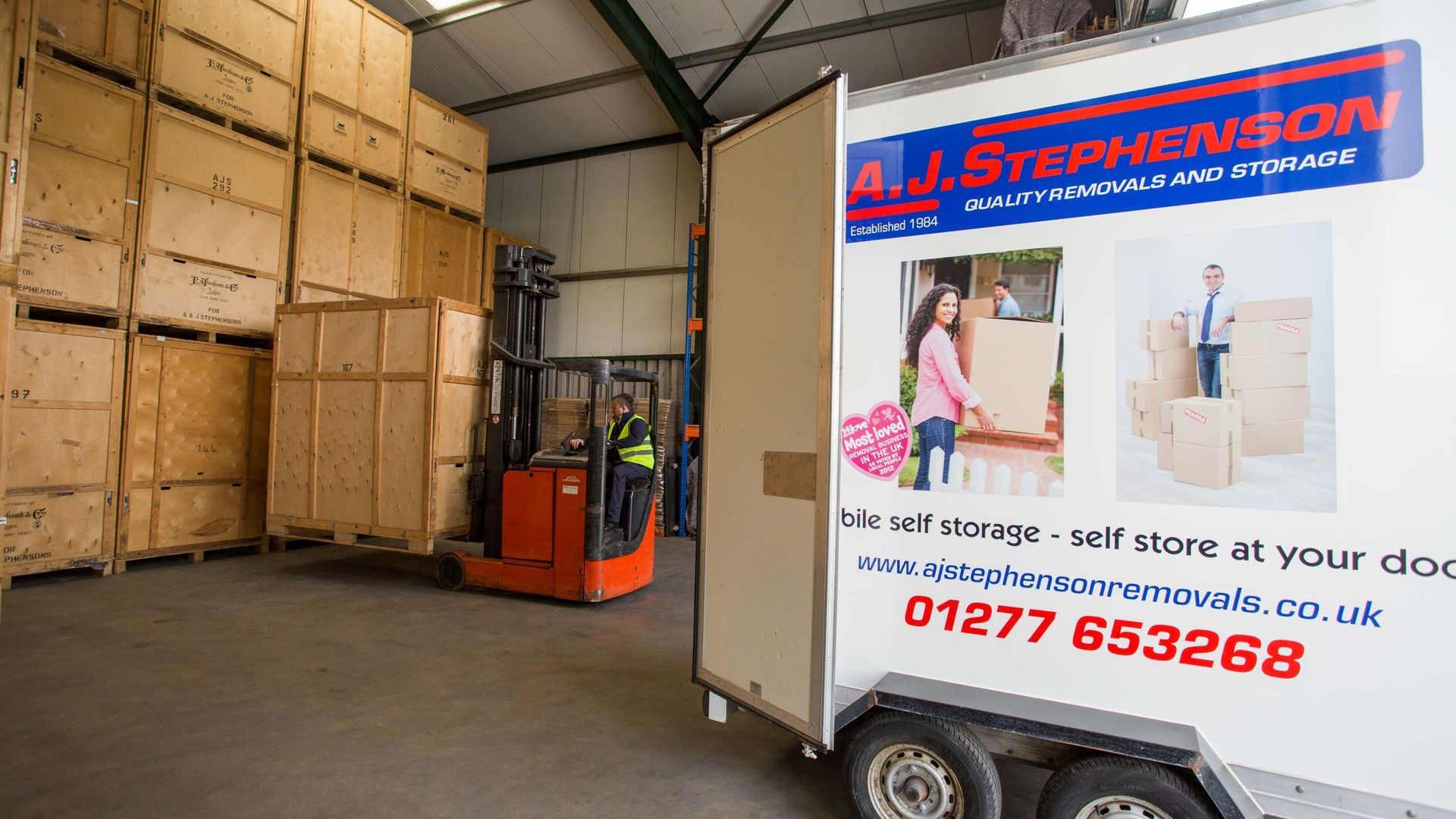 A forklift is loading storage container into AJ Stephenson Removals' storage solutions.