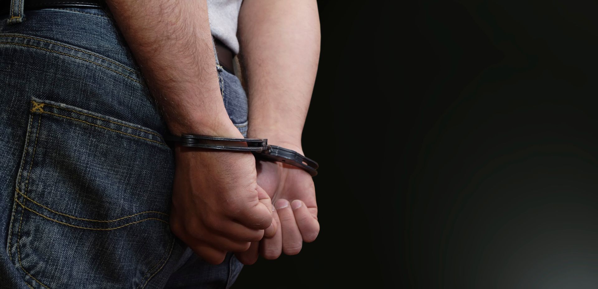 Hands cuffed behind back of person in jeans after DUI arrest. Hands cuffed behind back of person in jeans after DUI arrest.