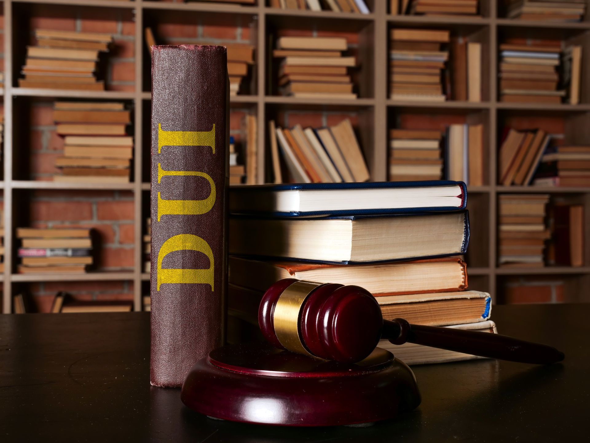 A DUI law book stands next to a gavel in a library.