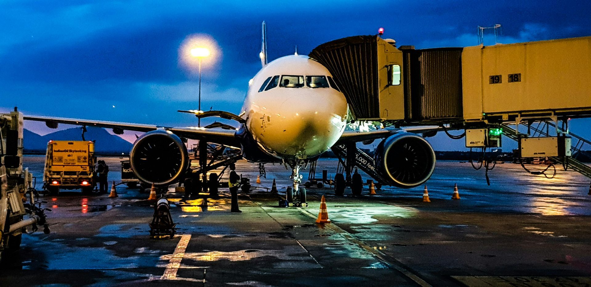 An airplane is parked on the tarmac at an airport at night.