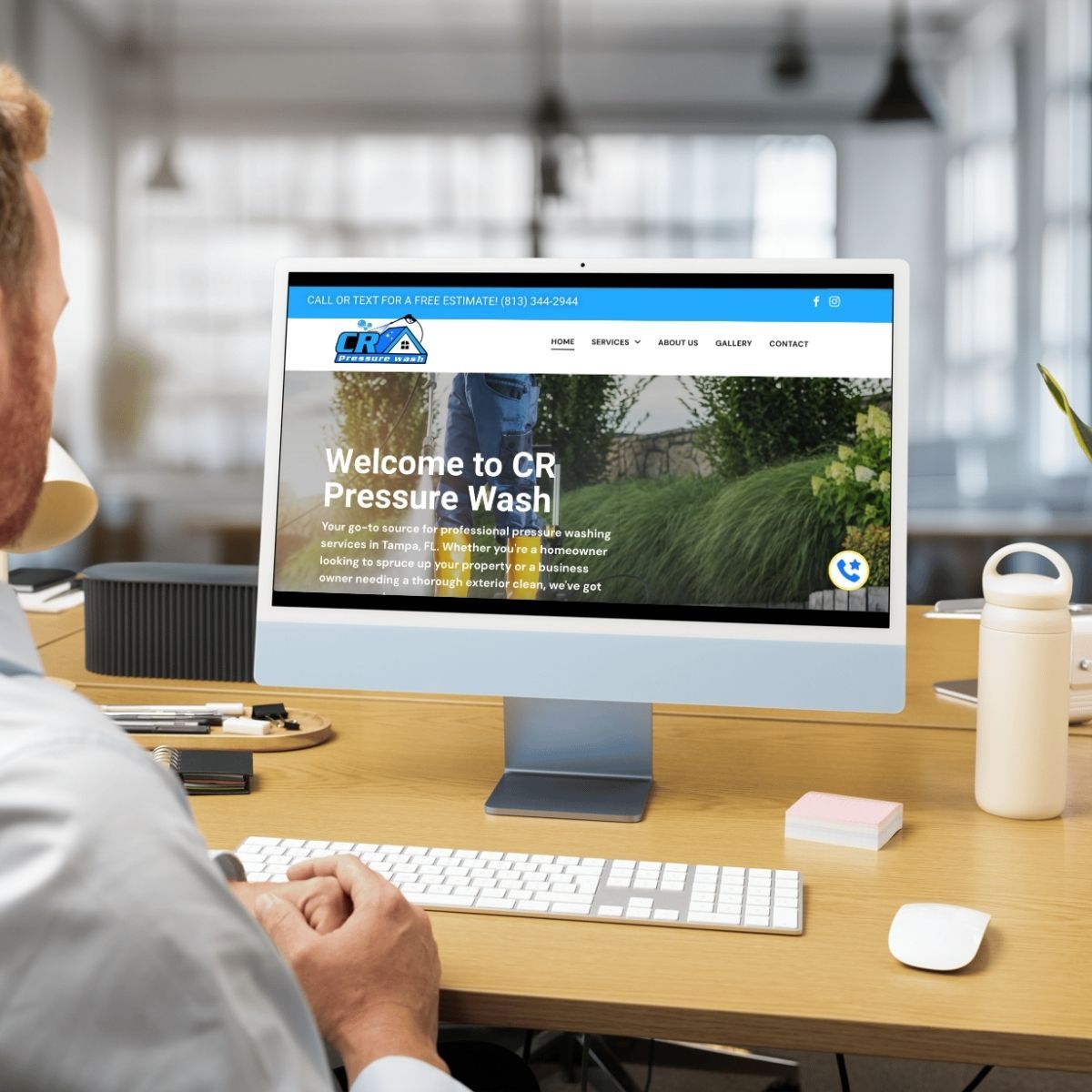 Man seated at a desk viewing the CR Pressure Wash website on a desktop computer.