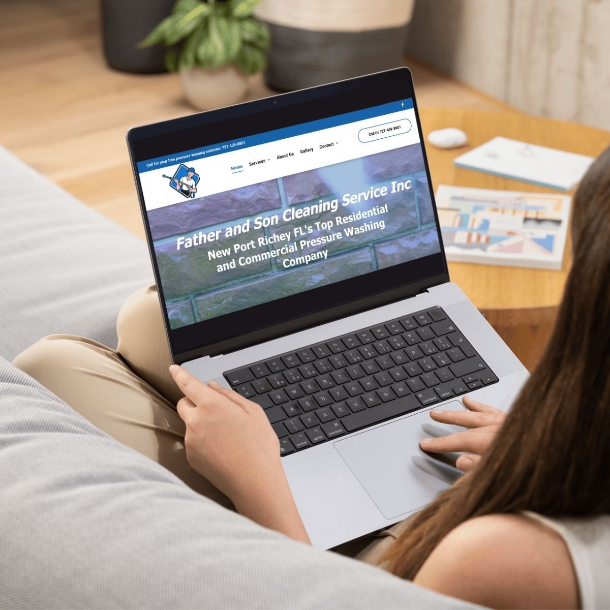 Person using a laptop on a couch, viewing the website for Father and Son Cleaning Service.